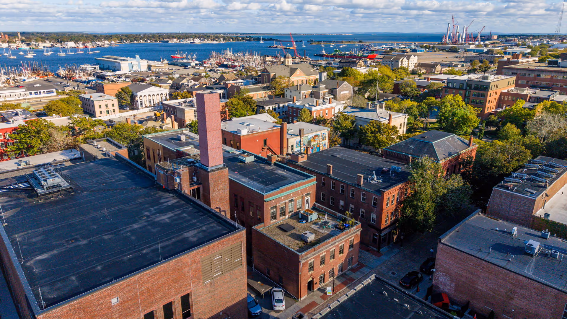 Aerial view of a coastal city with brick buildings and a harbor.