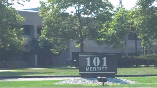 Exterior view of a building with 101 Merritt sign and surrounding trees