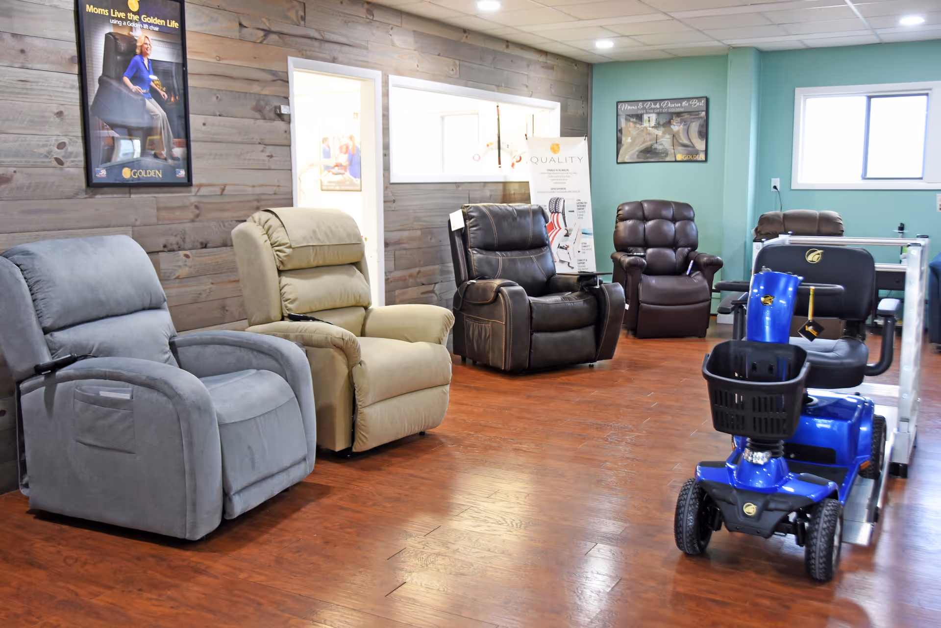 Interior showroom with several recliner chairs along a wood-paneled wall and a blue mobility scooter.