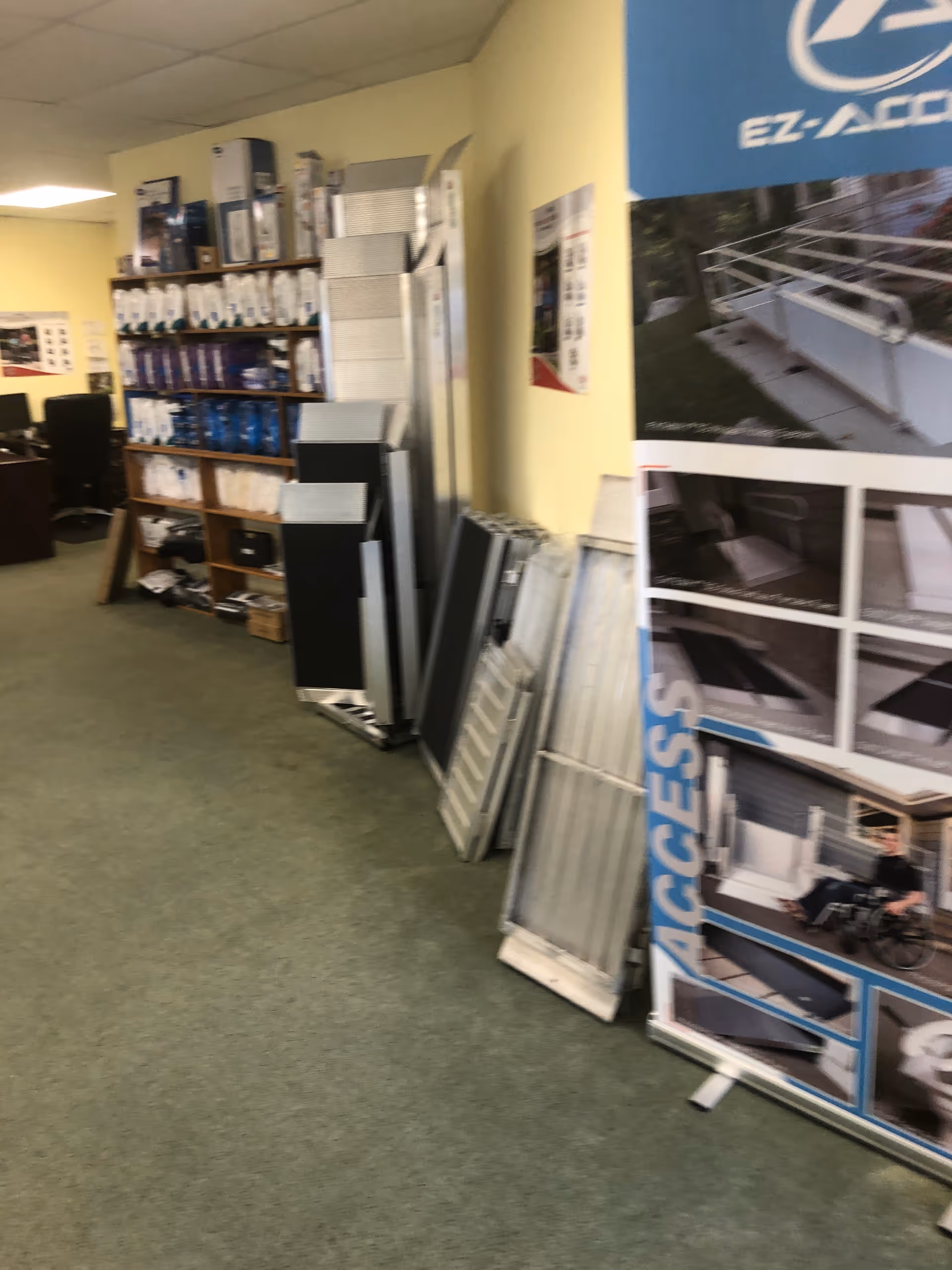 Interior showroom with shelves and display panels featuring mobility scooters and accessories.