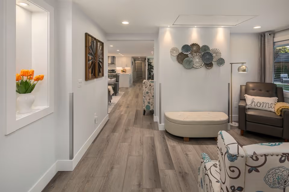 Bright modern hallway leads to a cozy living area with contemporary decor and seating.