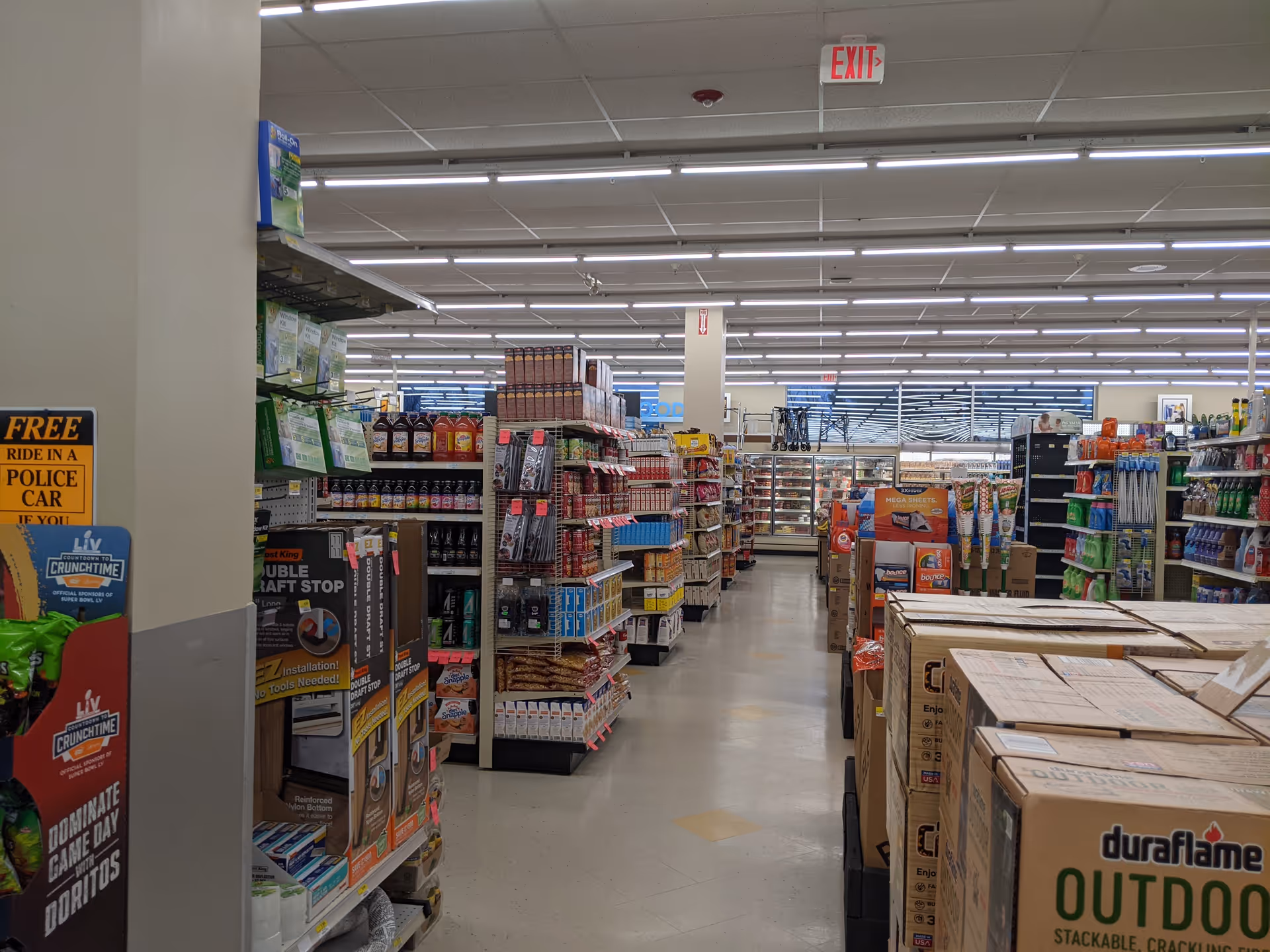 Interior of Discount Drug Mart with aisles, shelves stocked with items, and a checkout area.