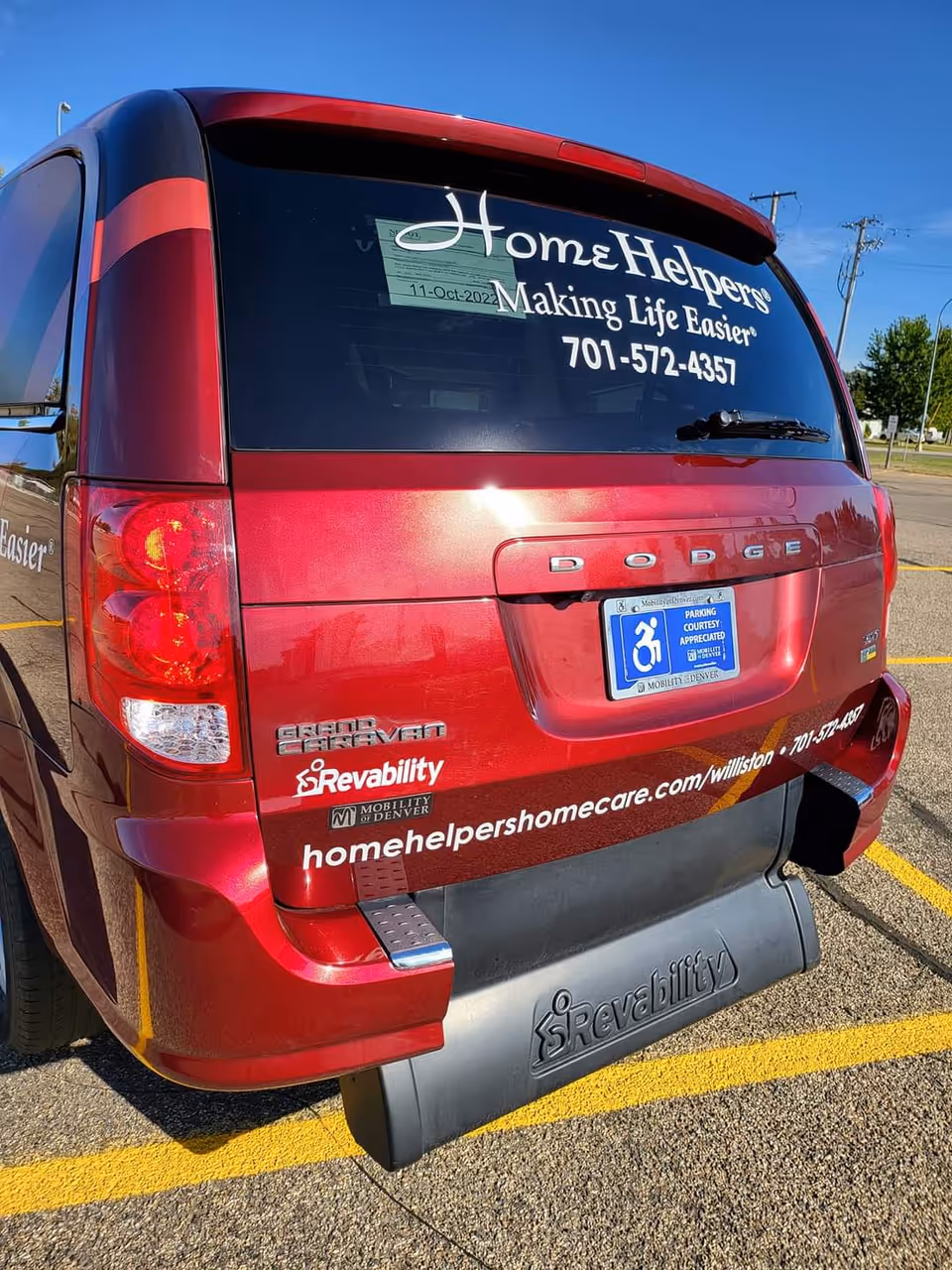 Red Home Helpers van, branding on rear window, parked in a lot.