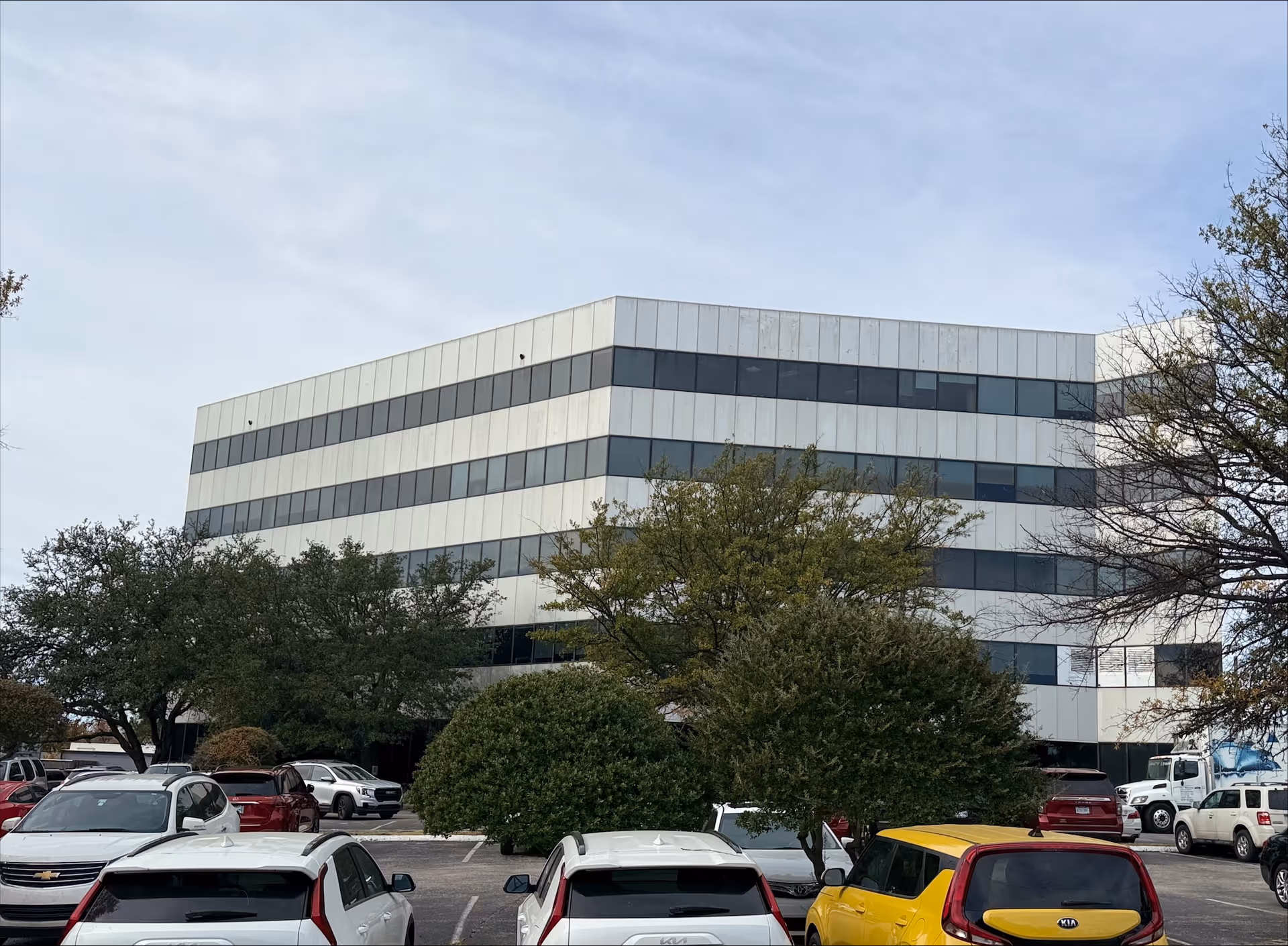 Modern, multi-story BrightStar Care building with glass windows and a surrounding parking lot.