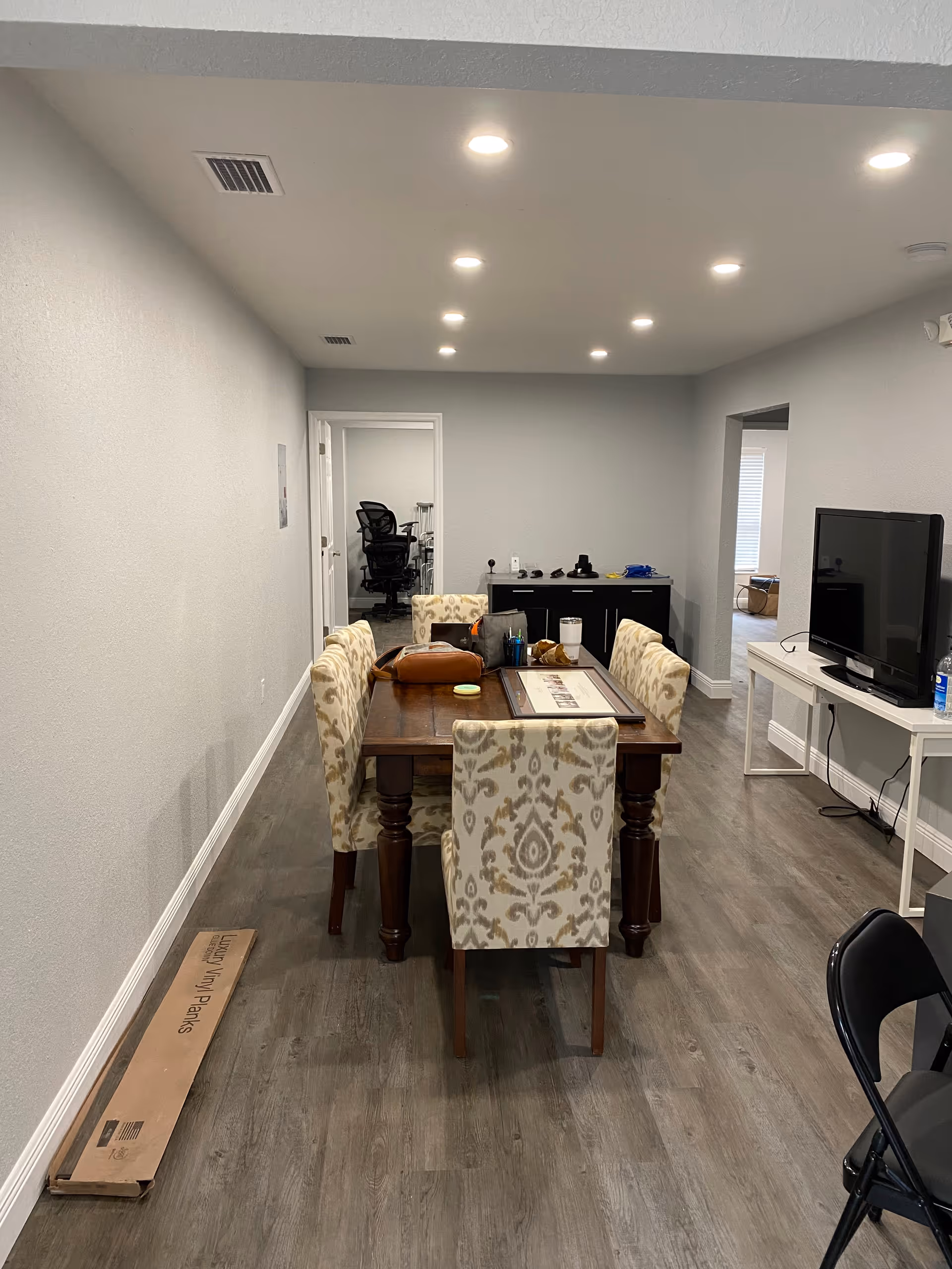 A dining table with upholstered chairs in a modern, well-lit senior living common area.