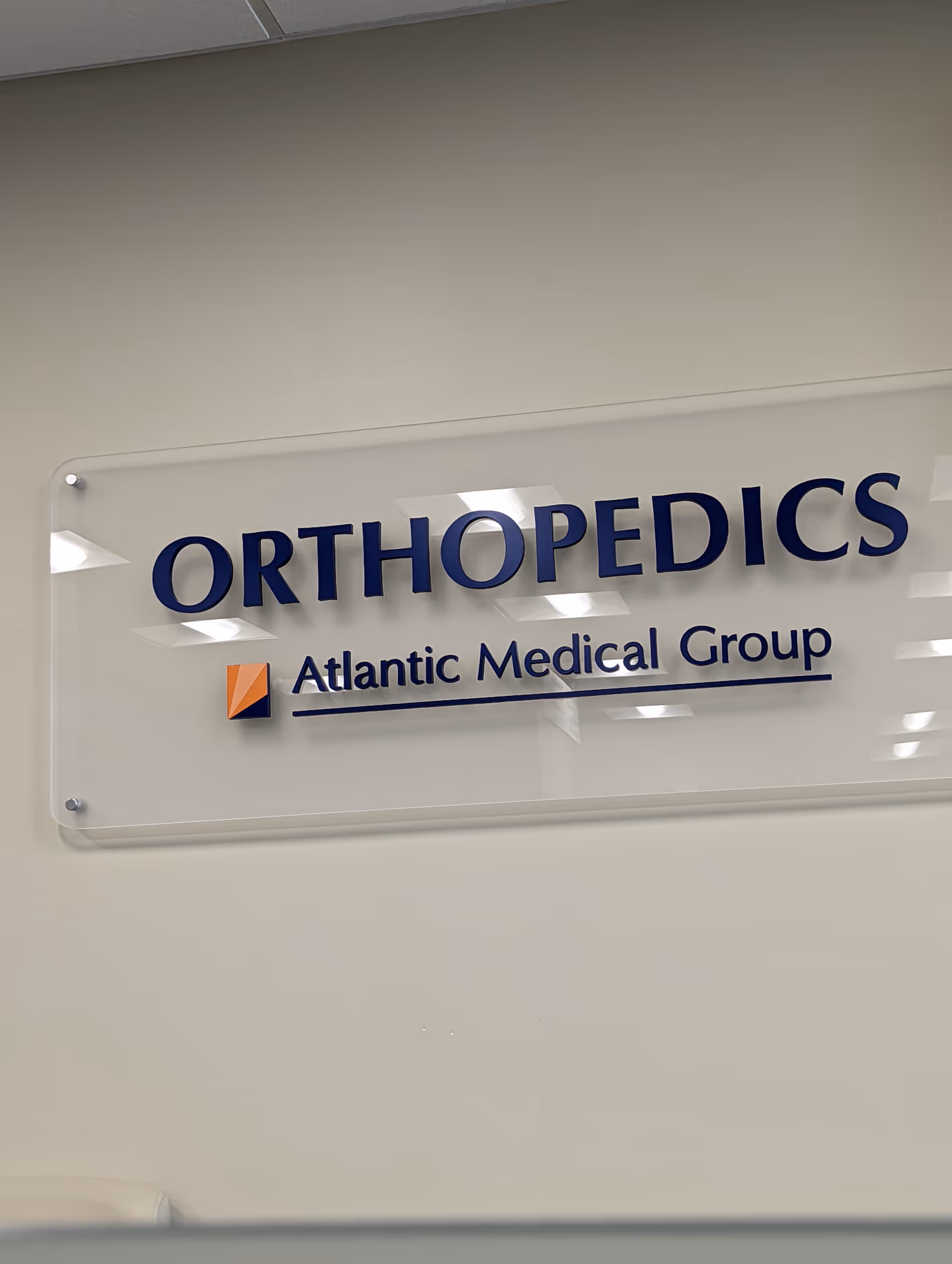 Indoor hallway wall with an Orthopedics sign and Atlantic Medical Group logo.