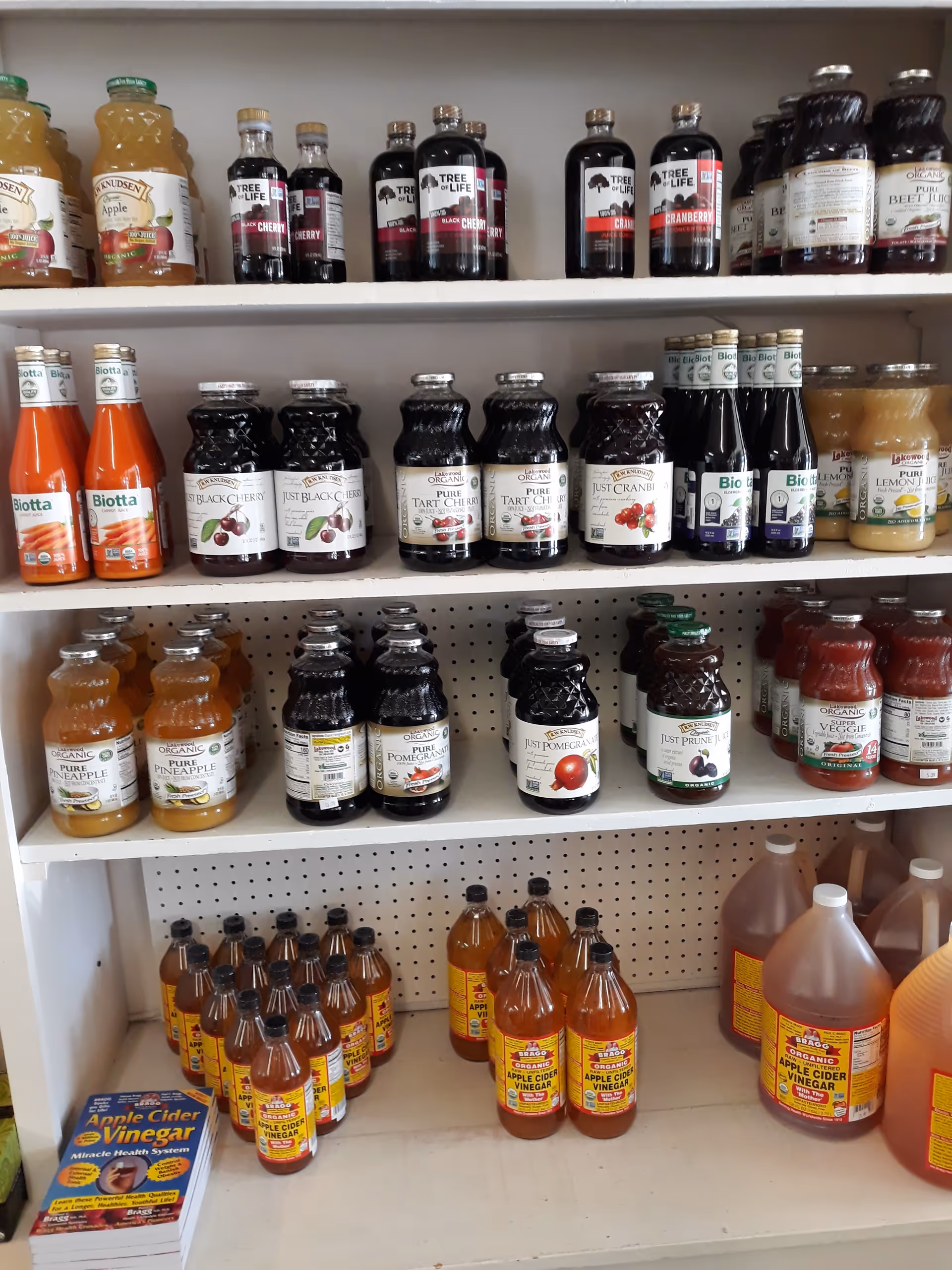 Shelves lined with bottled juices and drinks in a facility pantry.
