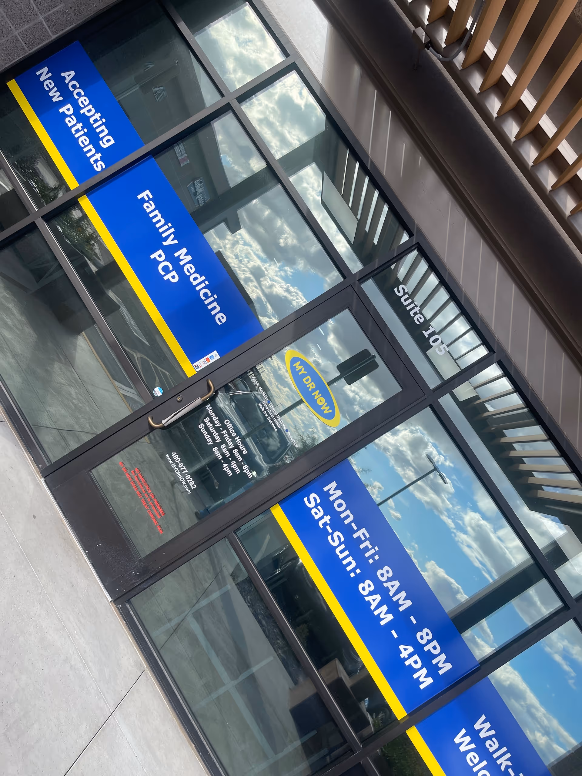 Exterior building entrance with glass doors and blue MY DR NOW signage.