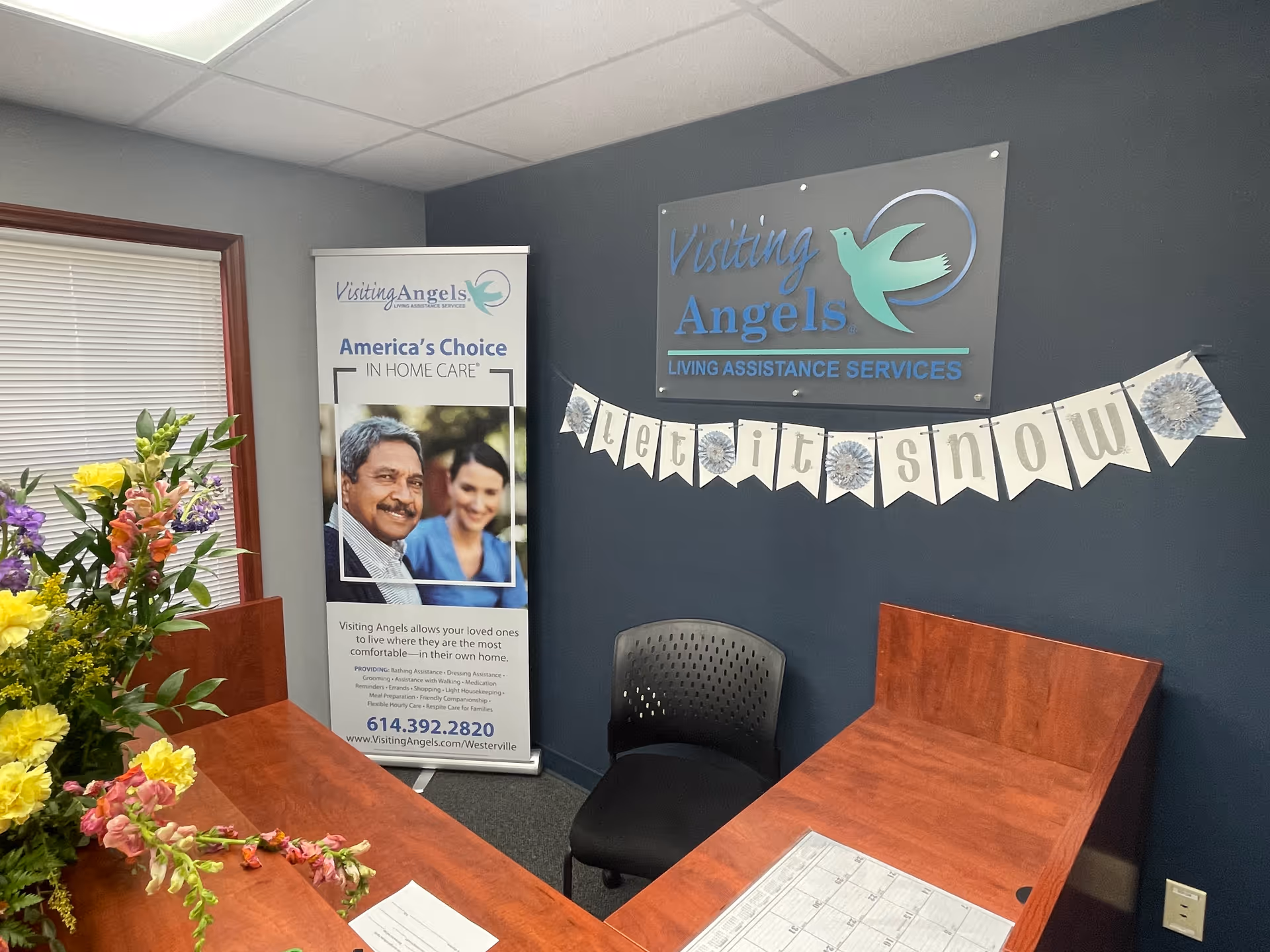 Reception area with a dark blue wall, banners, and a wooden desk.