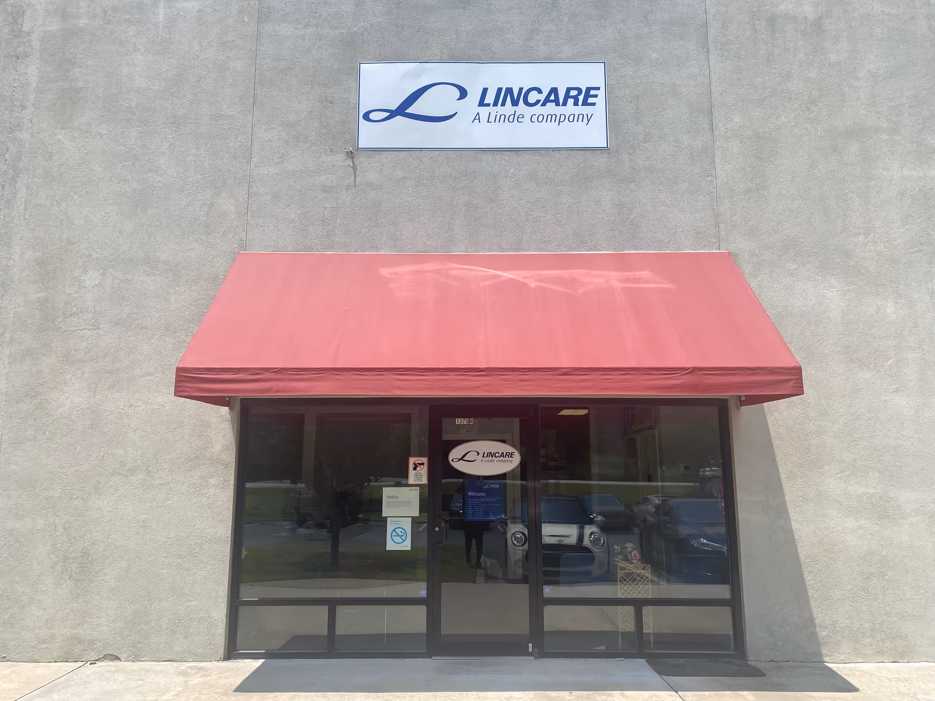 Facility entrance with a maroon awning and Lincare sign on a concrete façade.