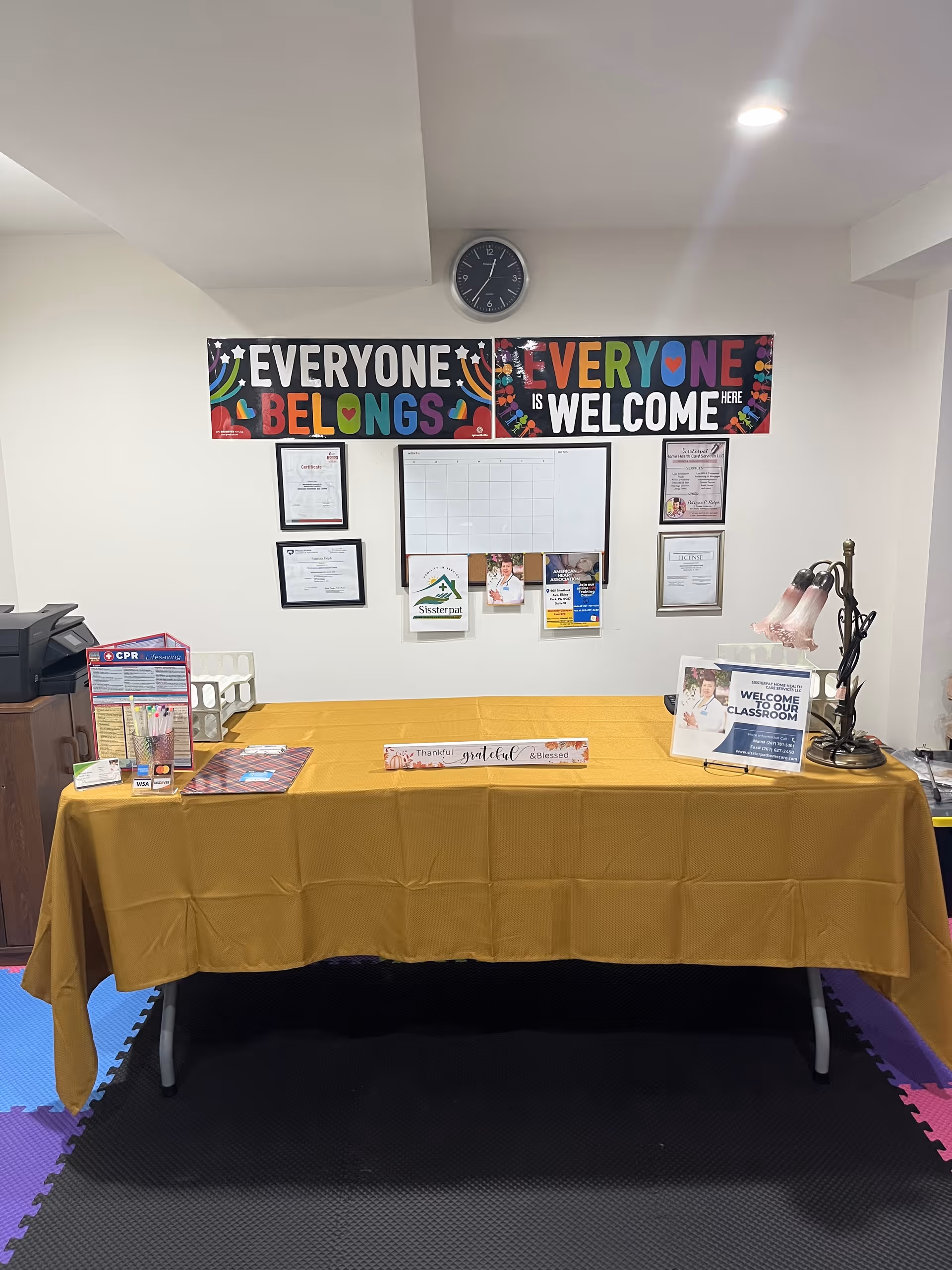 Reception area with a long yellow-draped table, banners, and wall notices.