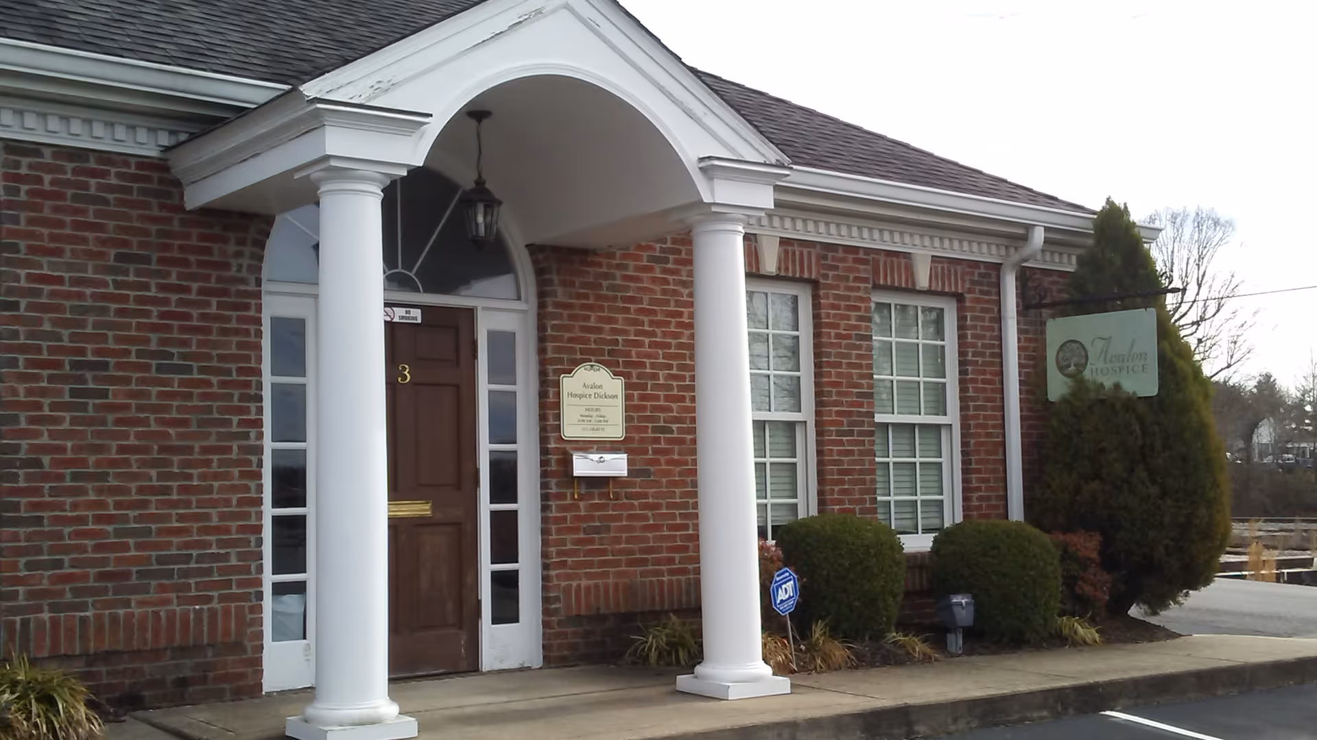 Gentiva Hospice building with white columns, arched entry, and a front sign.