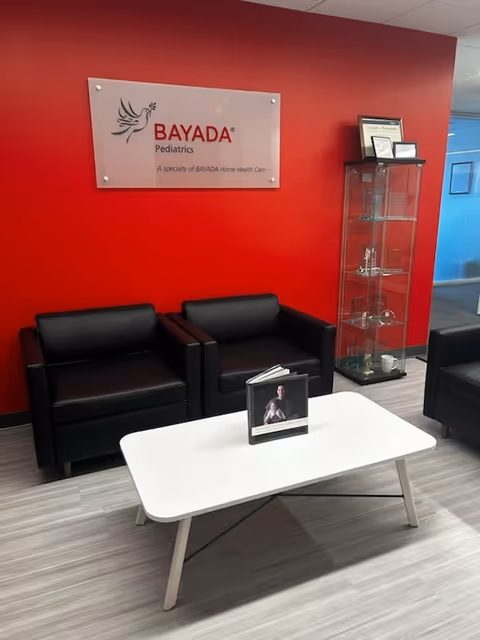 Lobby seating area with red wall and BAYADA Pediatrics sign.