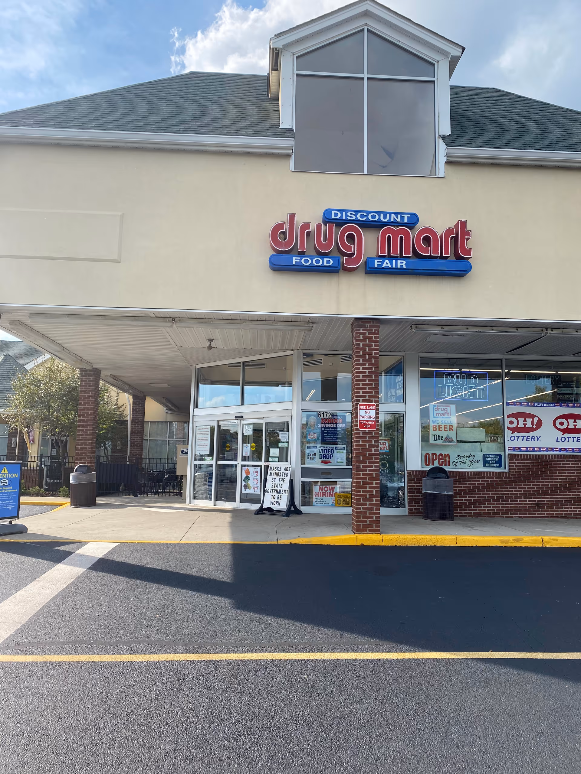 Front view of Discount Drug Mart storefront with glass doors and parking.