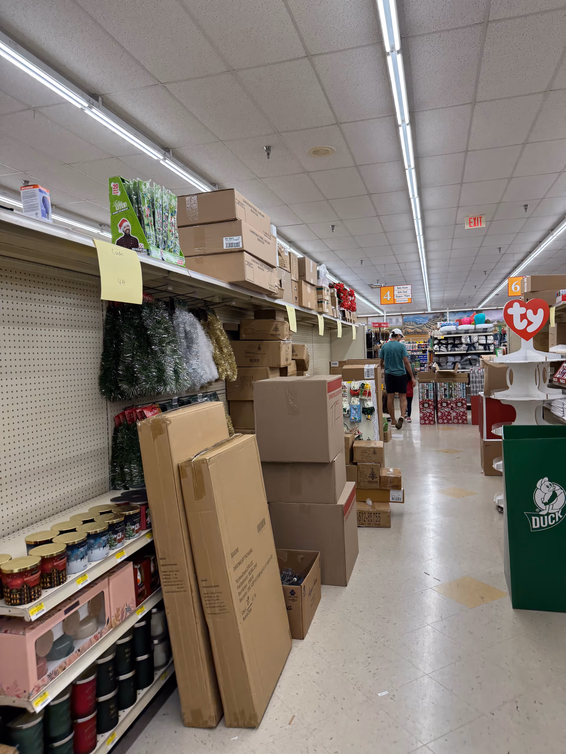Aisle in Discount Drug Mart with stacked boxes and shelves.