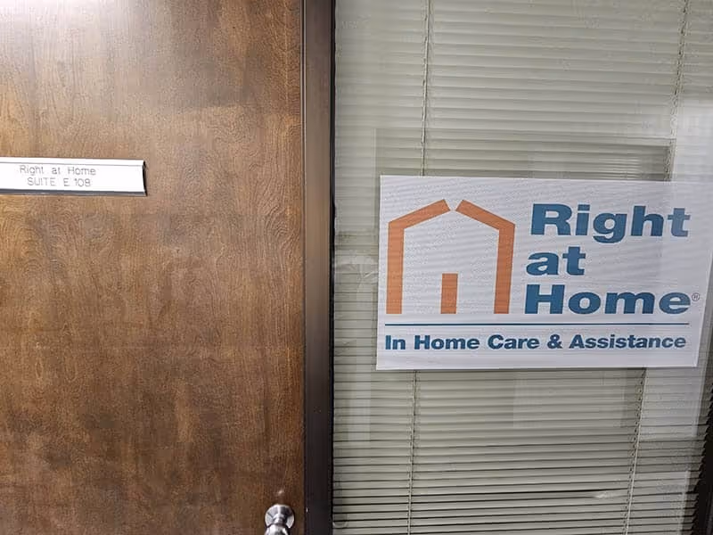 Wood door next to window with Right at Home sign reading In Home Care & Assistance.