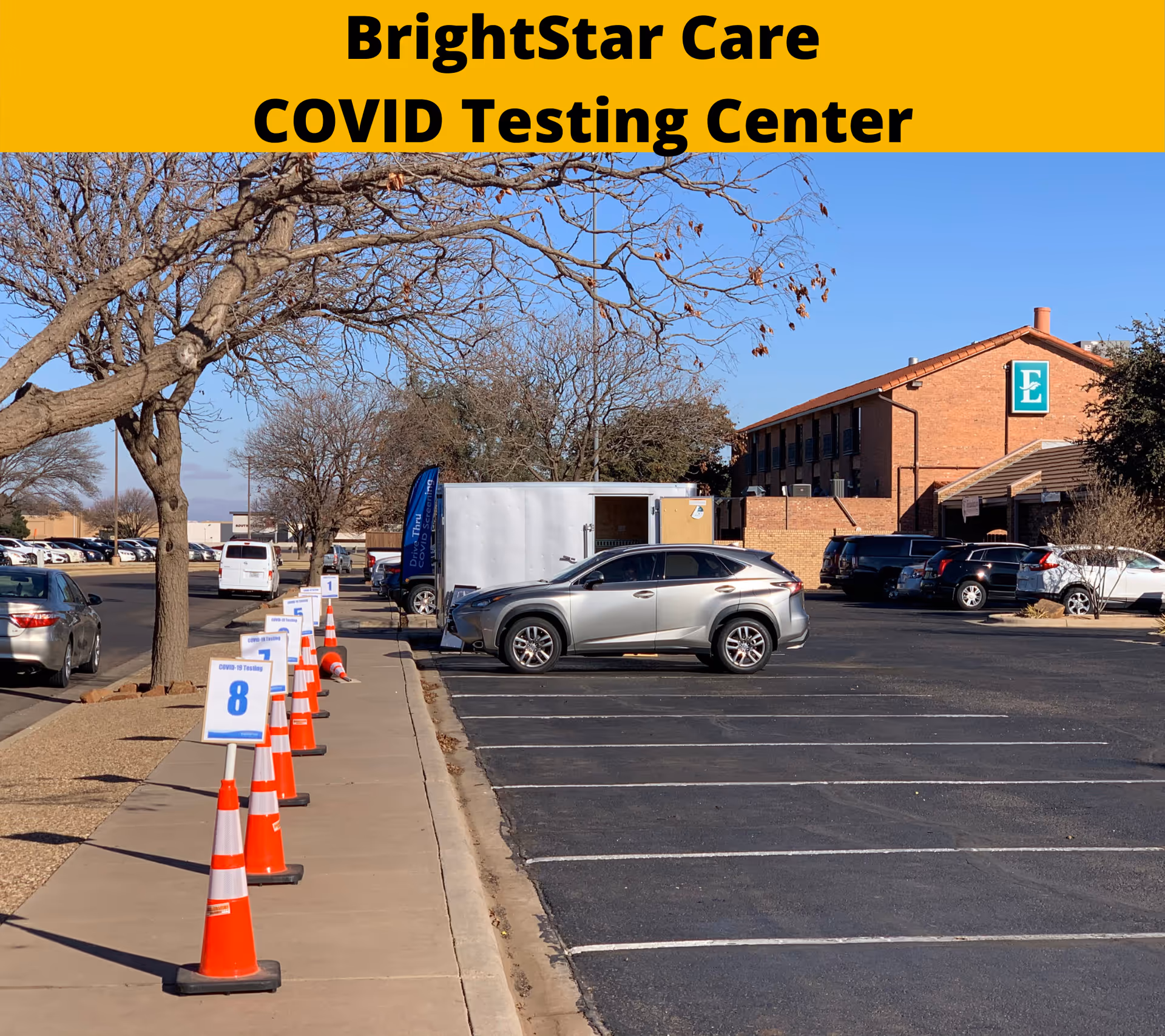 BrightStar Care COVID testing site in a parking lot with orange cones and a brick building.
