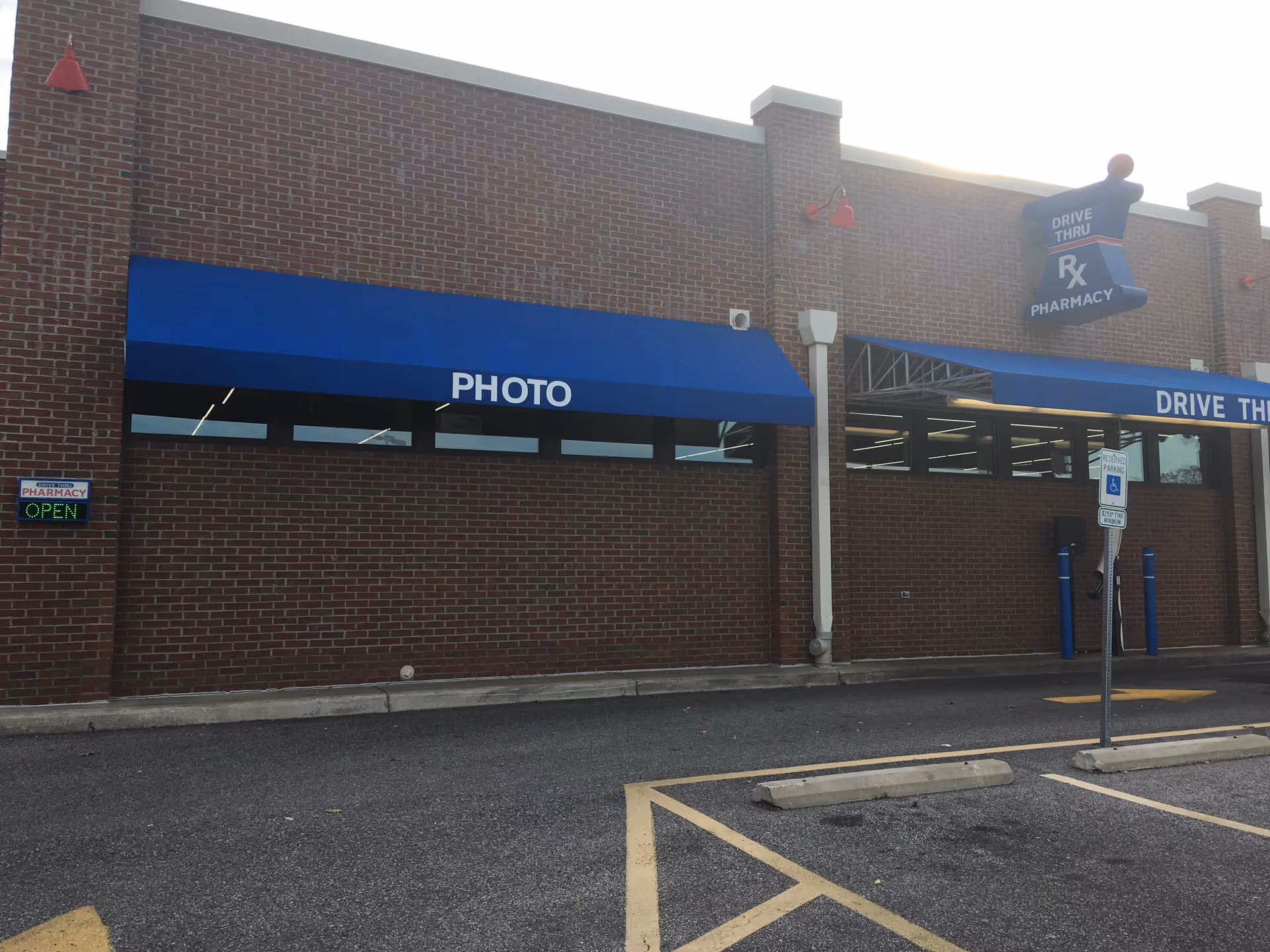Brick Discount Drug Mart storefront with blue awnings and drive-thru signage.