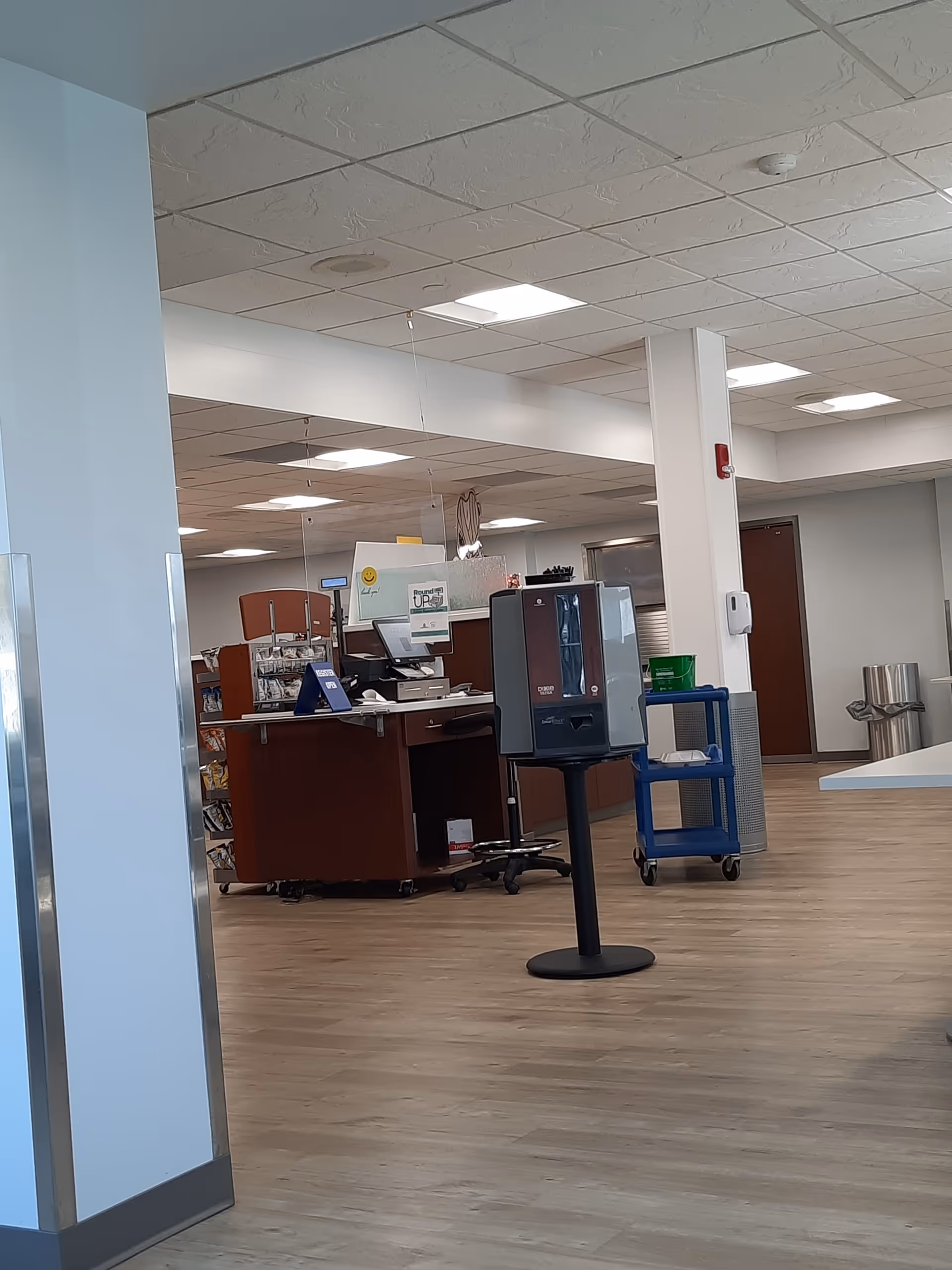 Interior of a hospital lobby with a reception desk and equipment in a wood-floored space