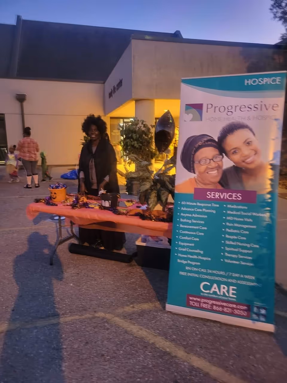 Outdoor event at Progressive Home Health and Hospice with a table and promotional banner.