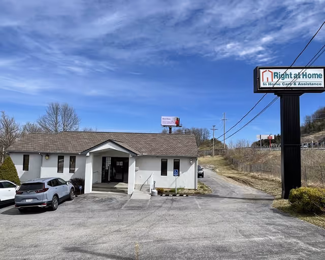 Small single-story building with Right at Home sign, parking lot, and rural surroundings