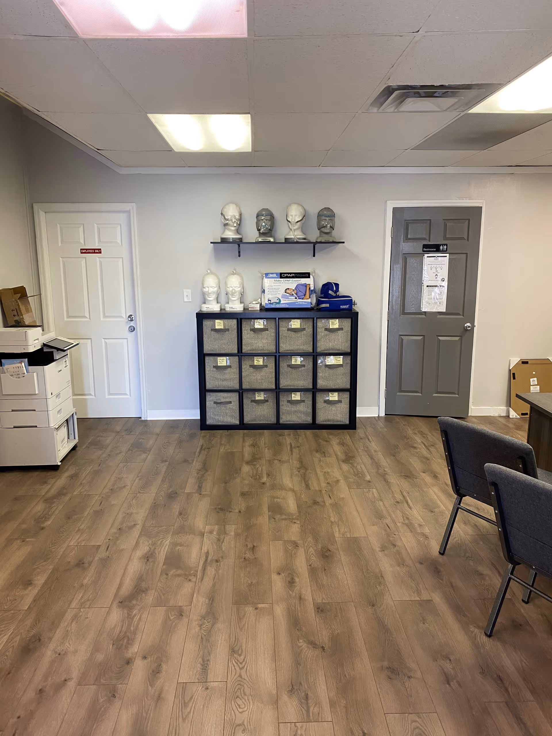 Interior room with cubby storage, mannequin heads on a shelf, and seating.