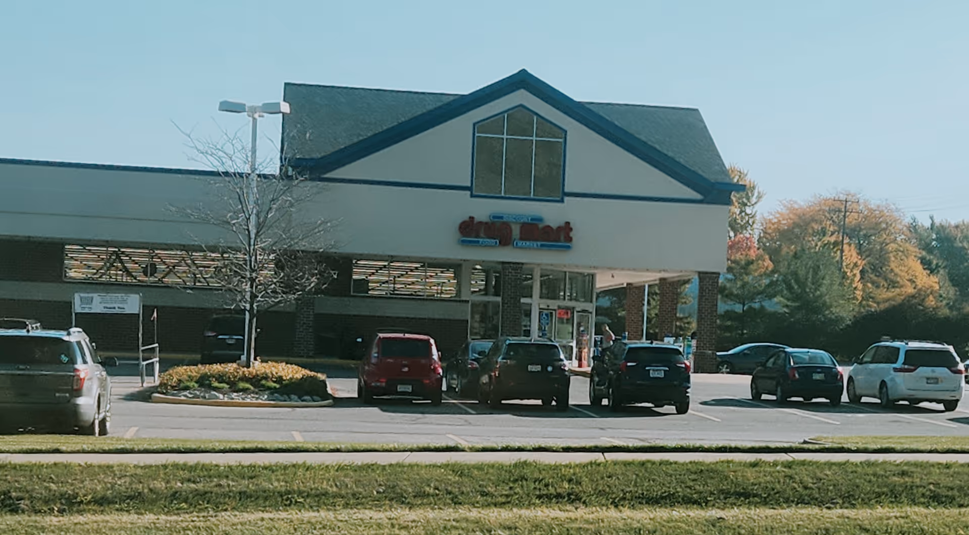 Front view of a Discount Drug Mart storefront with cars in the parking lot.