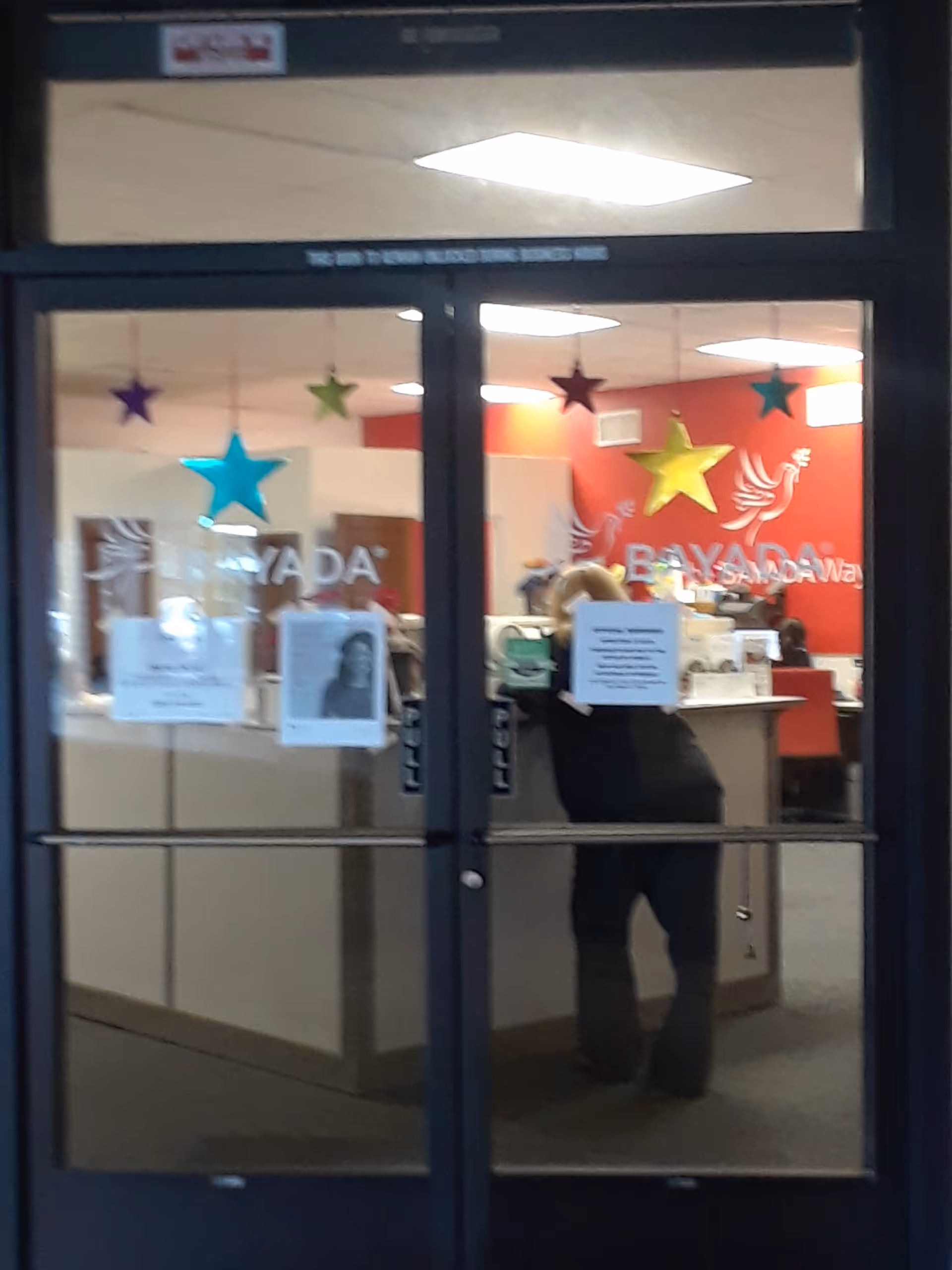 Inside BAYADA Home Health reception area visible through glass doors with star decorations