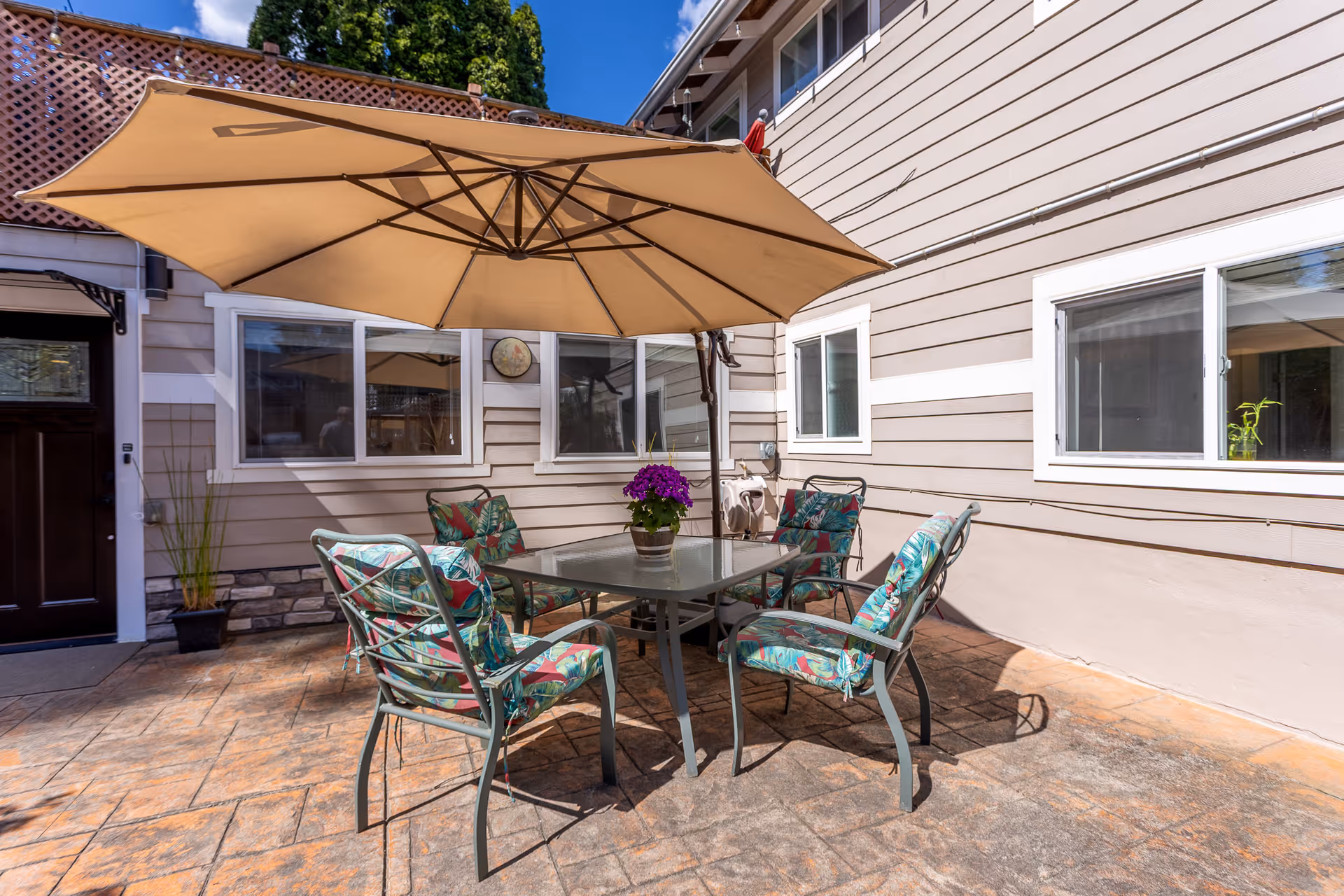 Outdoor patio with table, umbrella, and patterned chairs at a senior living facility.