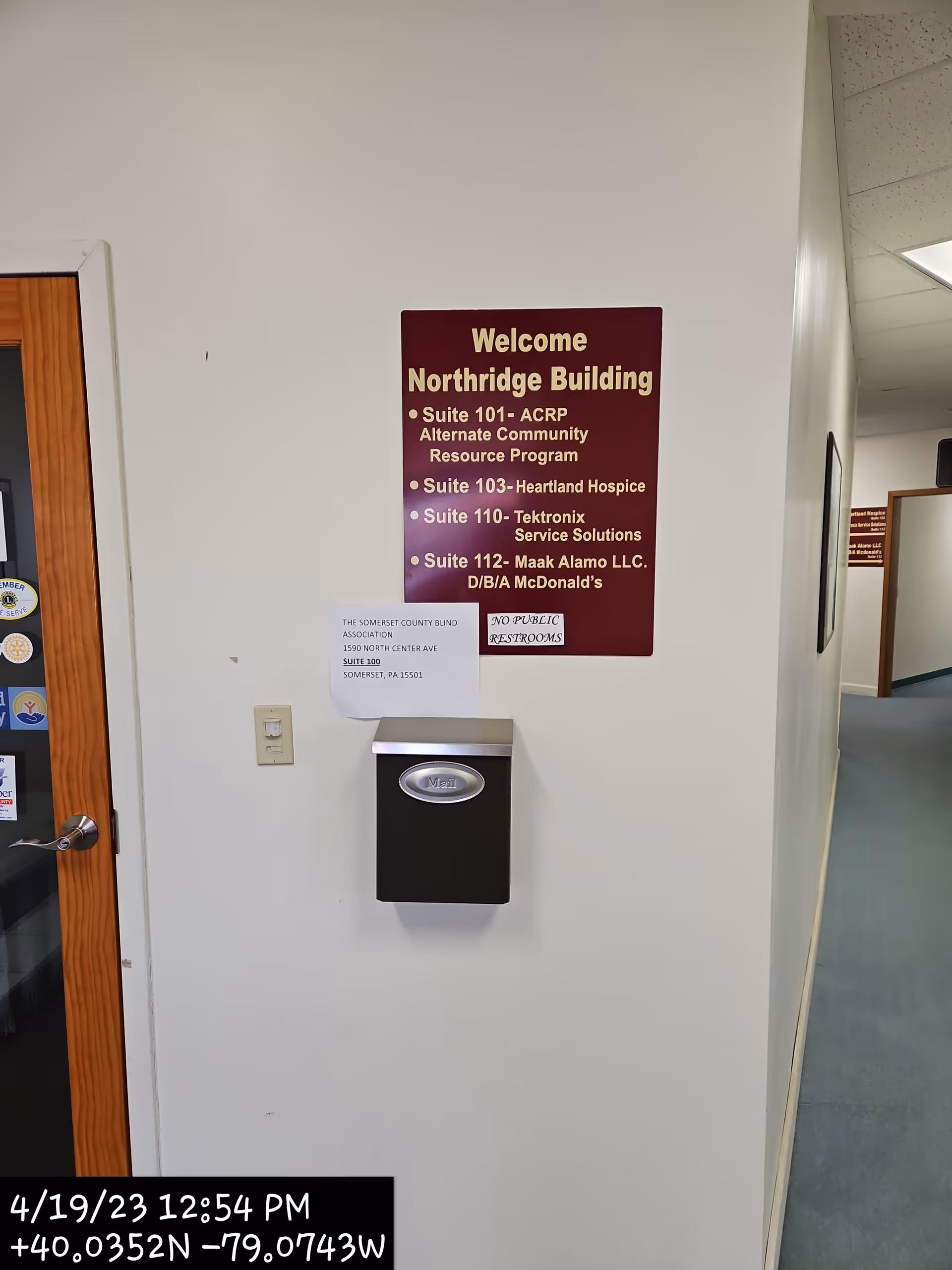 Interior hallway with a brown welcome sign and wall-mounted mailbox.