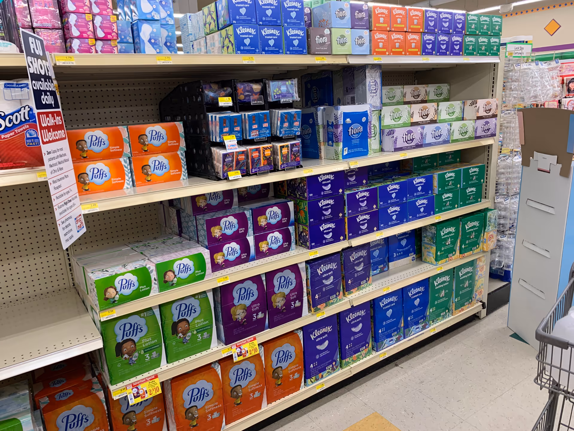Aisle of Discount Drug Mart with colorful tissue boxes stacked on shelves.