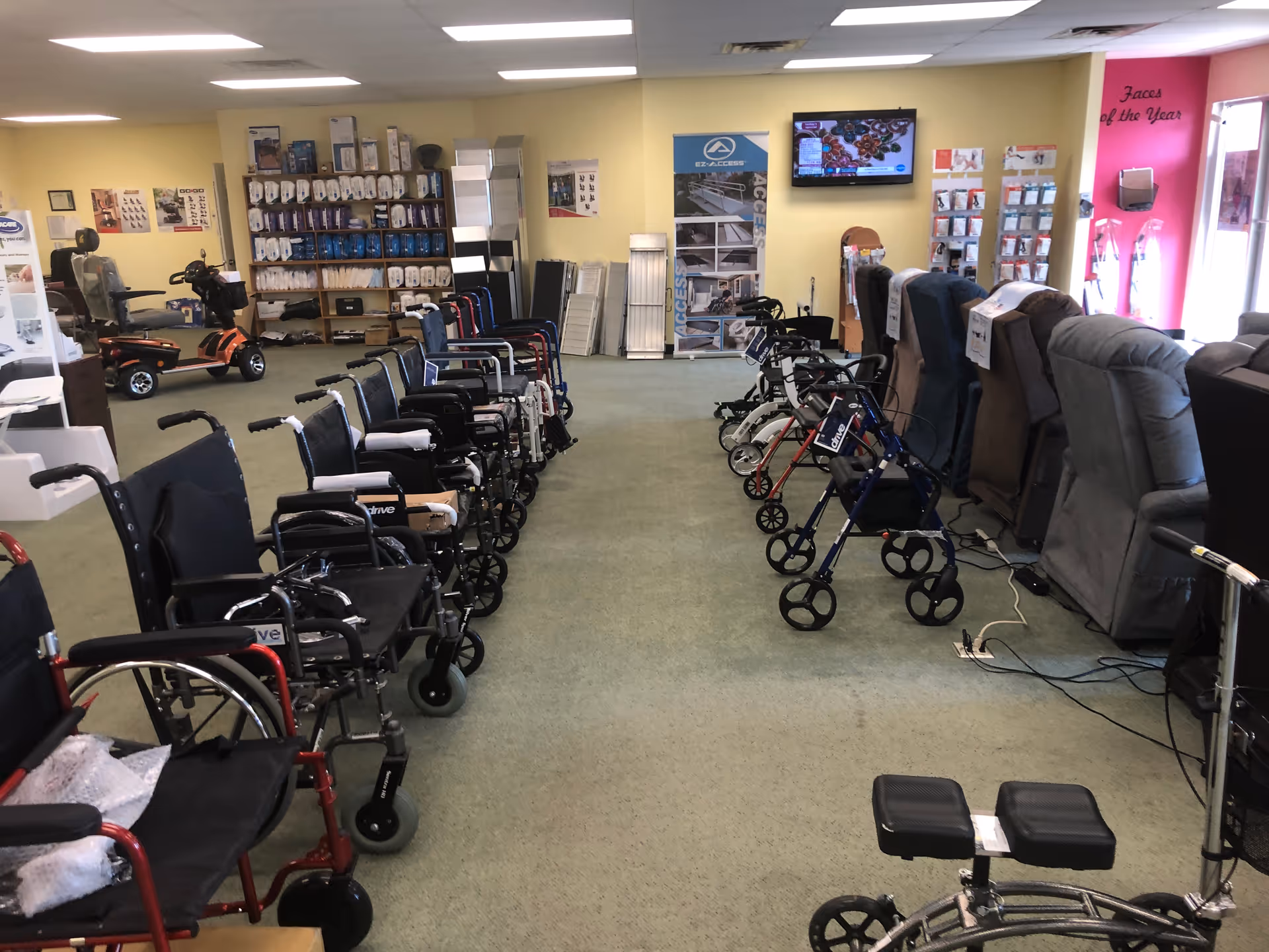 Indoor showroom with rows of wheelchairs, mobility scooters, and recliners.