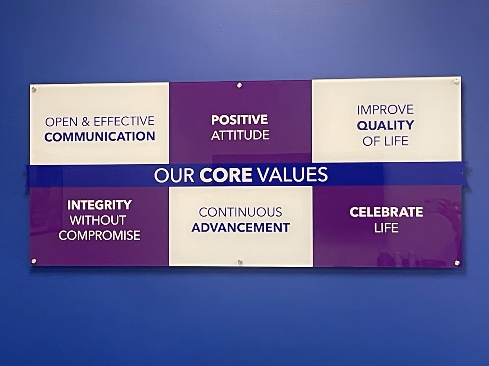Blue wall with three-panel sign displaying 'Our Core Values' and six values.