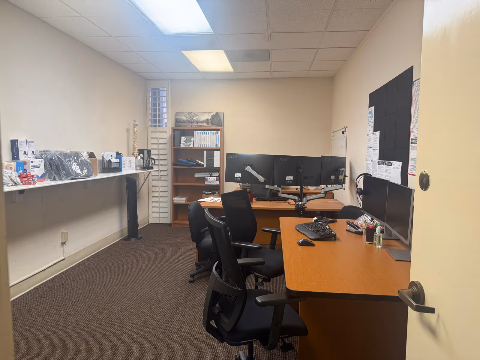 Office workspace with desks, monitors, and filing shelves in a senior facility.