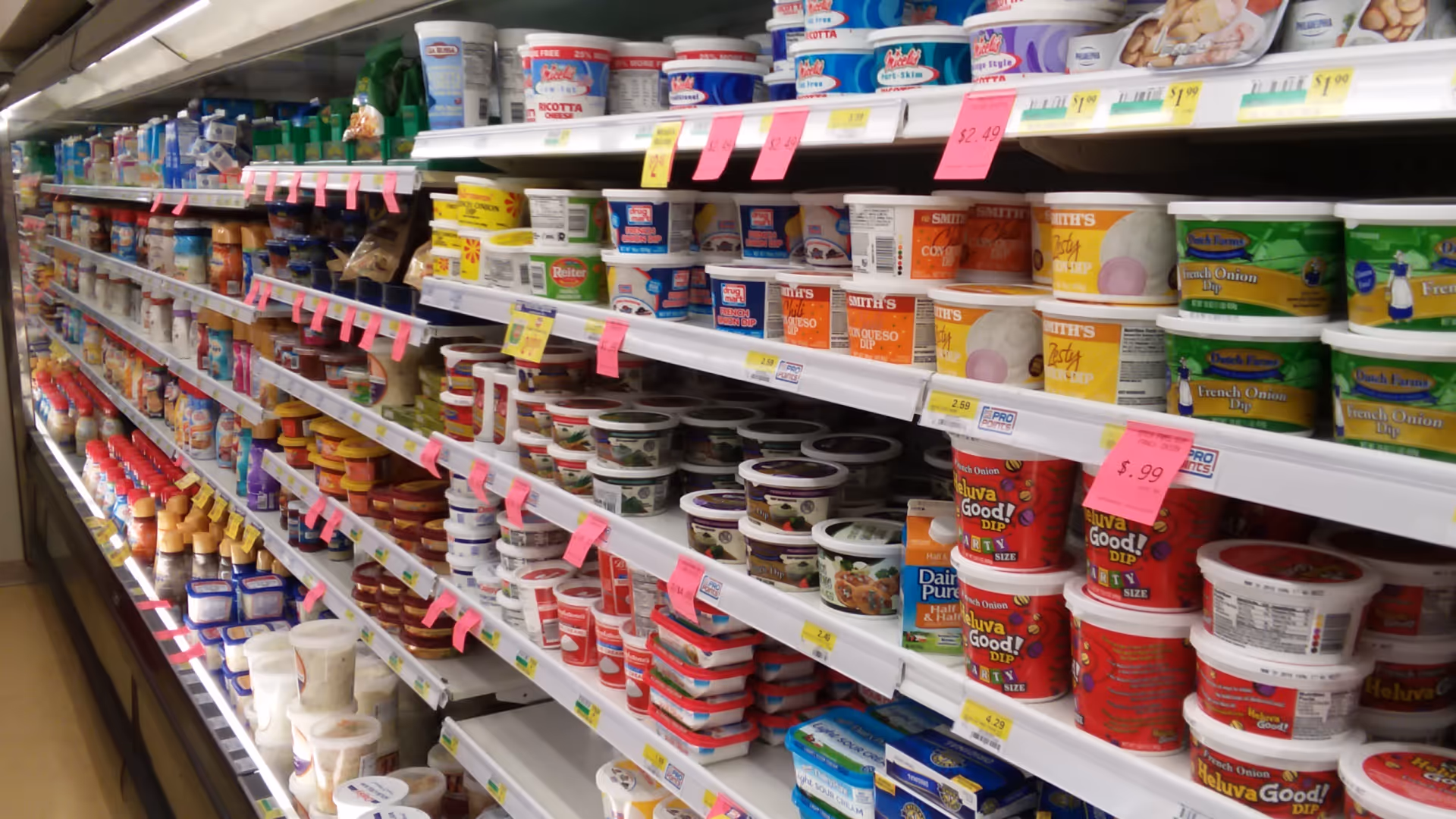 Aisle of dairy products and yogurts on supermarket shelves.