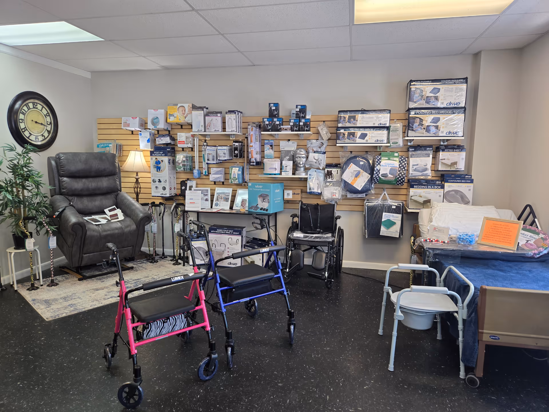 Indoor showroom room with wheelchairs, walkers, and medical supplies displayed on wall shelves.