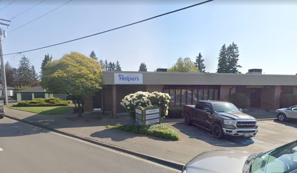 Exterior view of a Senior Helpers building with signage, a parked pickup truck, and landscaping.