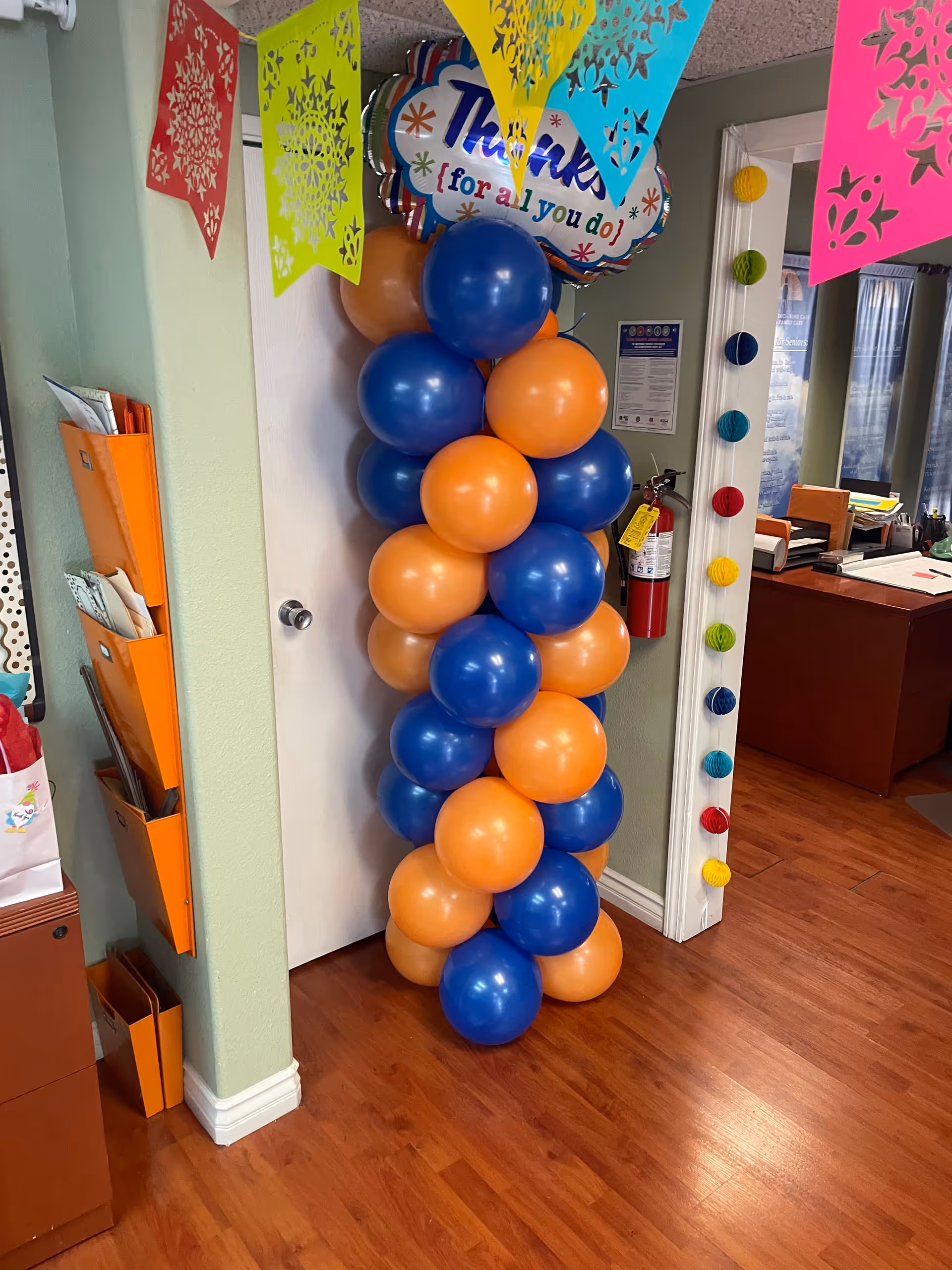 Colorful banners and blue-orange balloons decorate a hallway at Independence Assistance Inc.