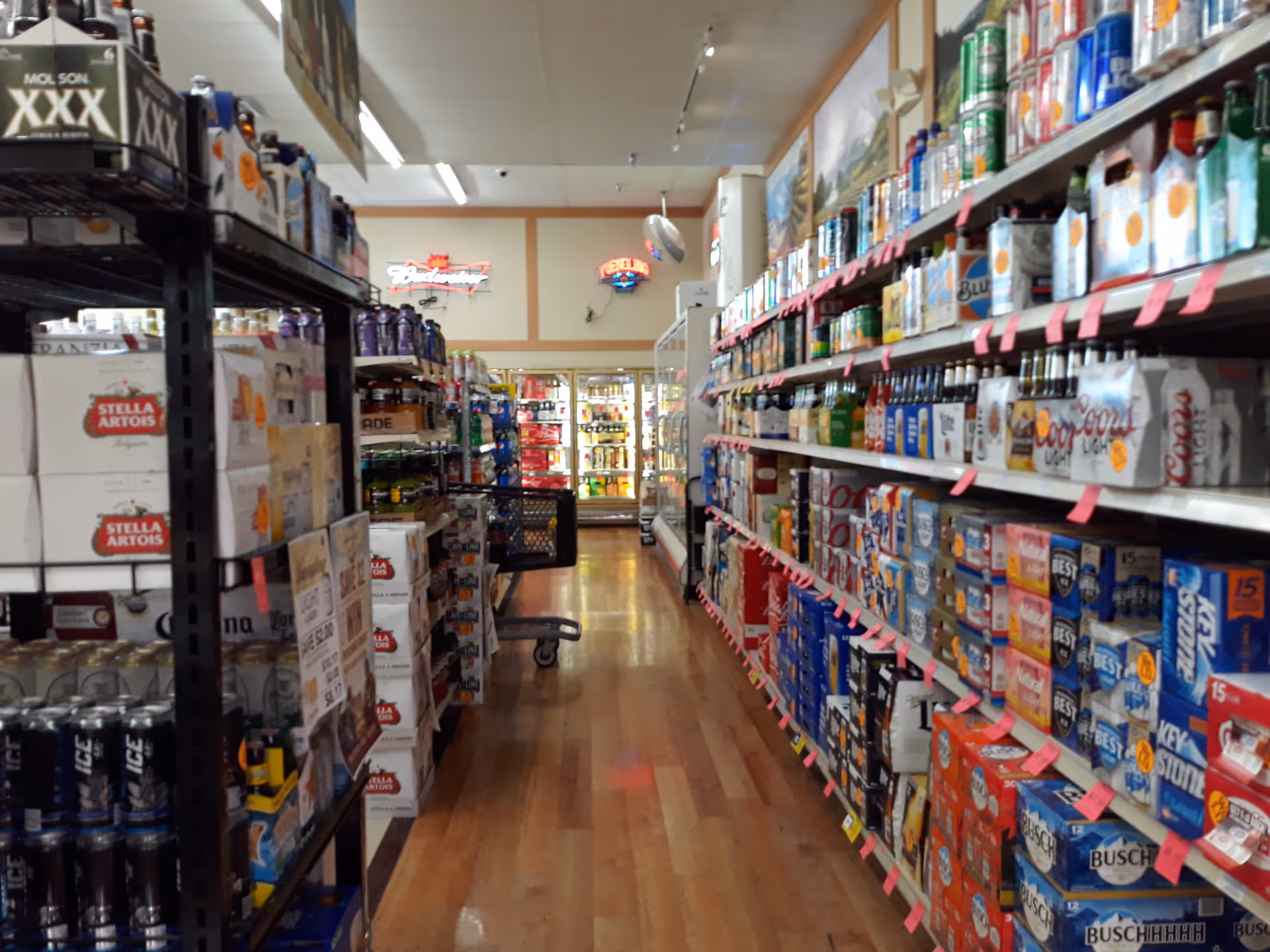 An aisle inside Discount Drug Mart with shelves stocked with beverages and products.
