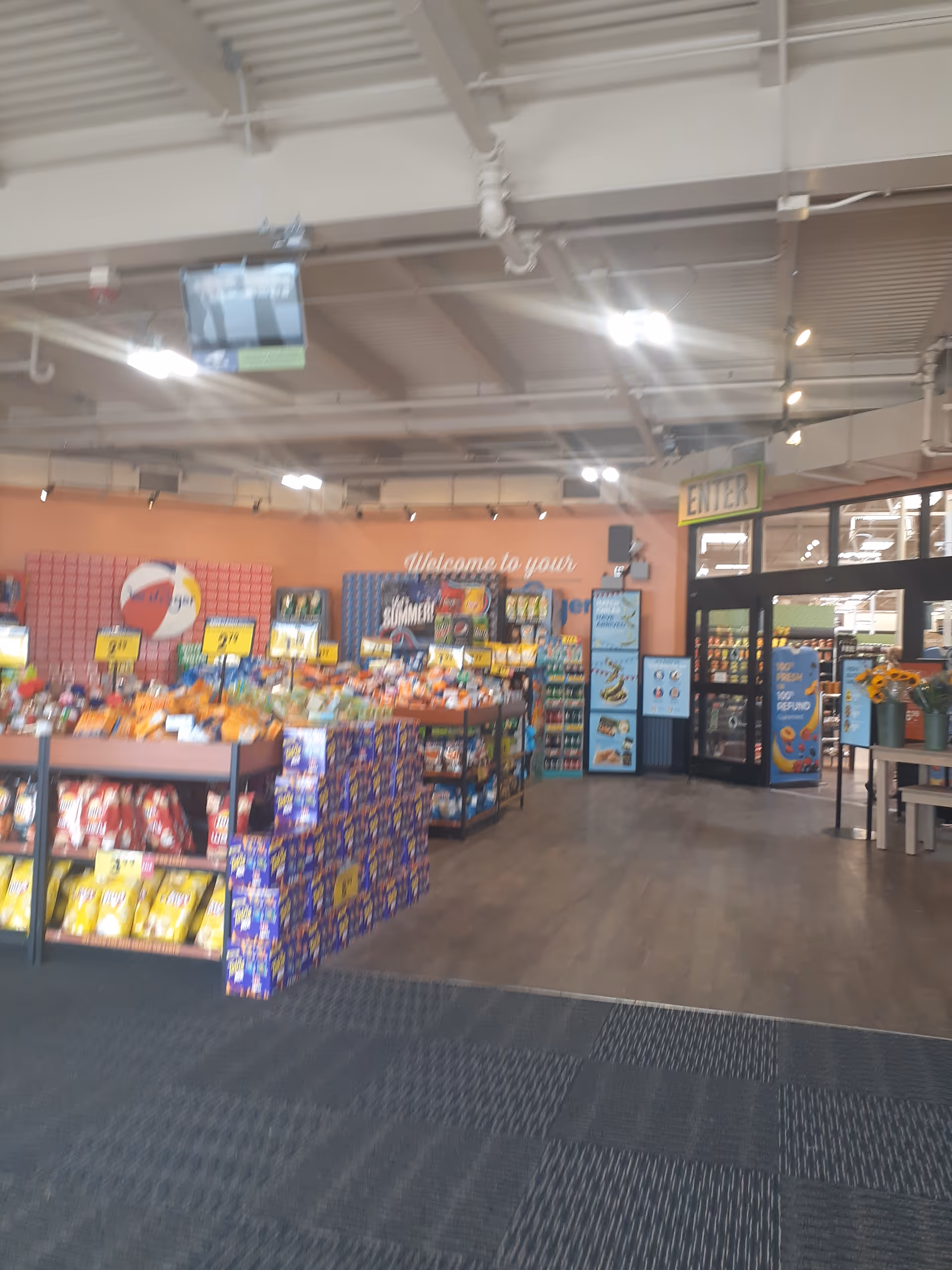 Interior of a Kroger store with snack displays and an entrance sign.