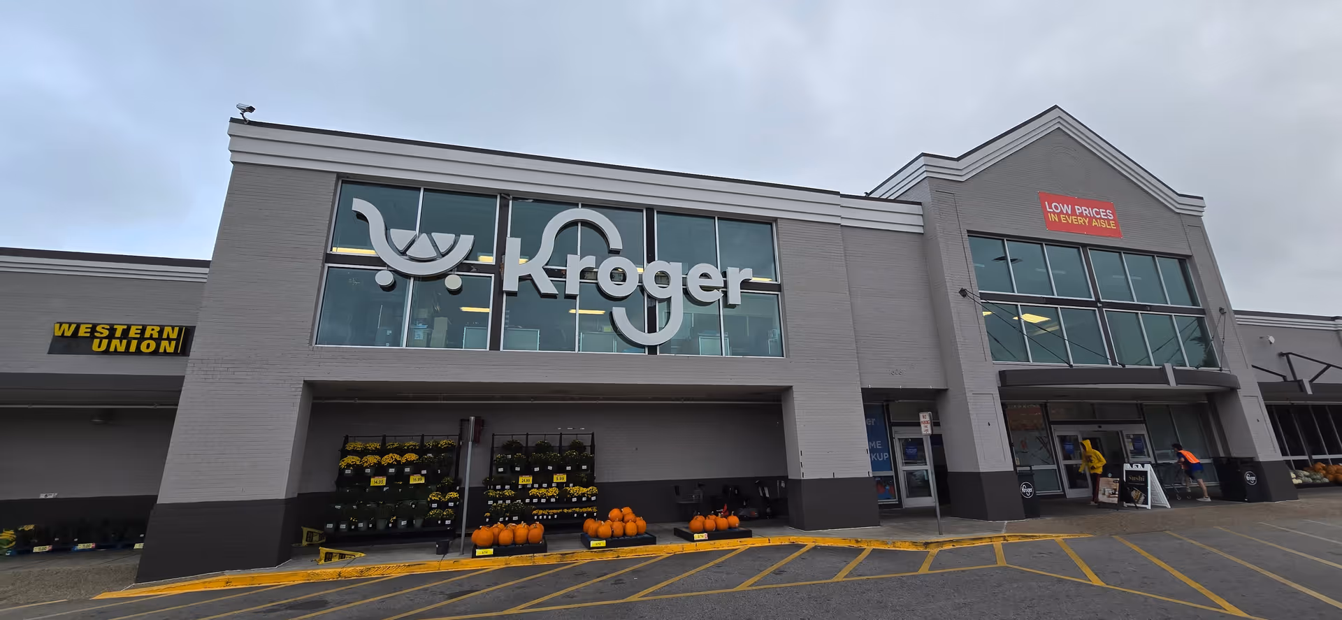 Exterior view of a Kroger storefront with pumpkins near the entrance