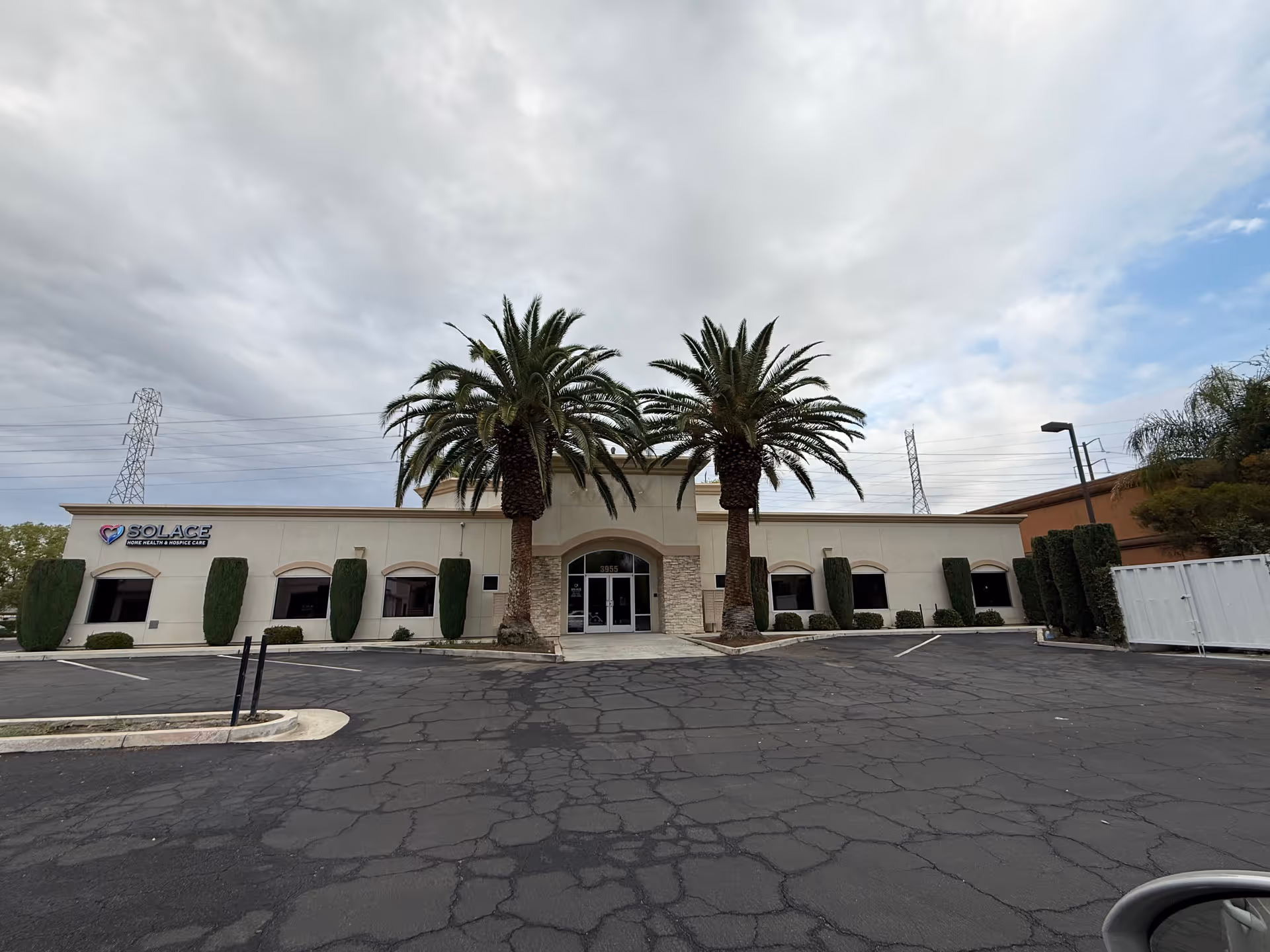 Solace Healthcare building front with palm trees and a parking lot.