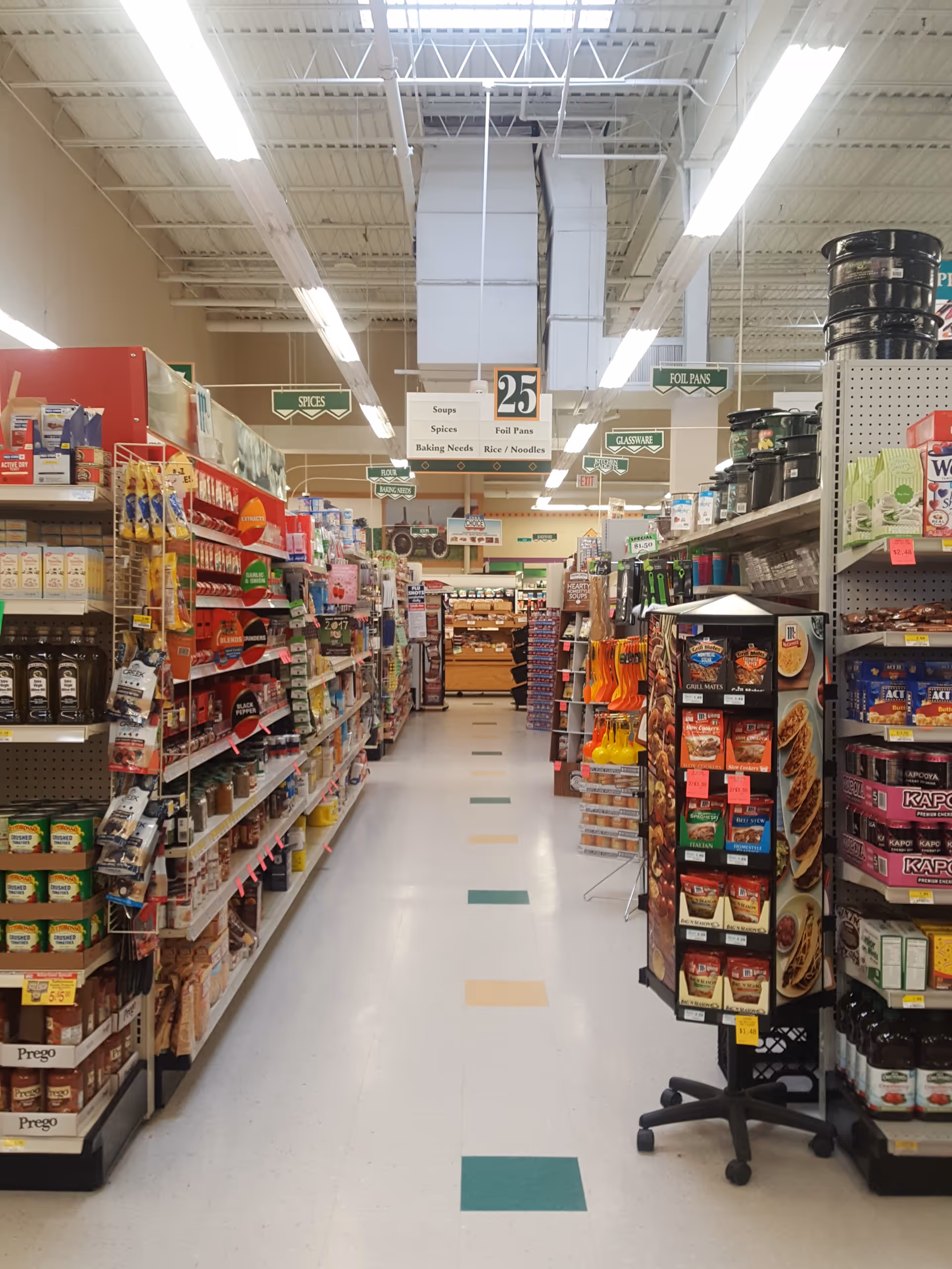 A brightly lit grocery aisle inside Discount Drug Mart with shelves full of products.
