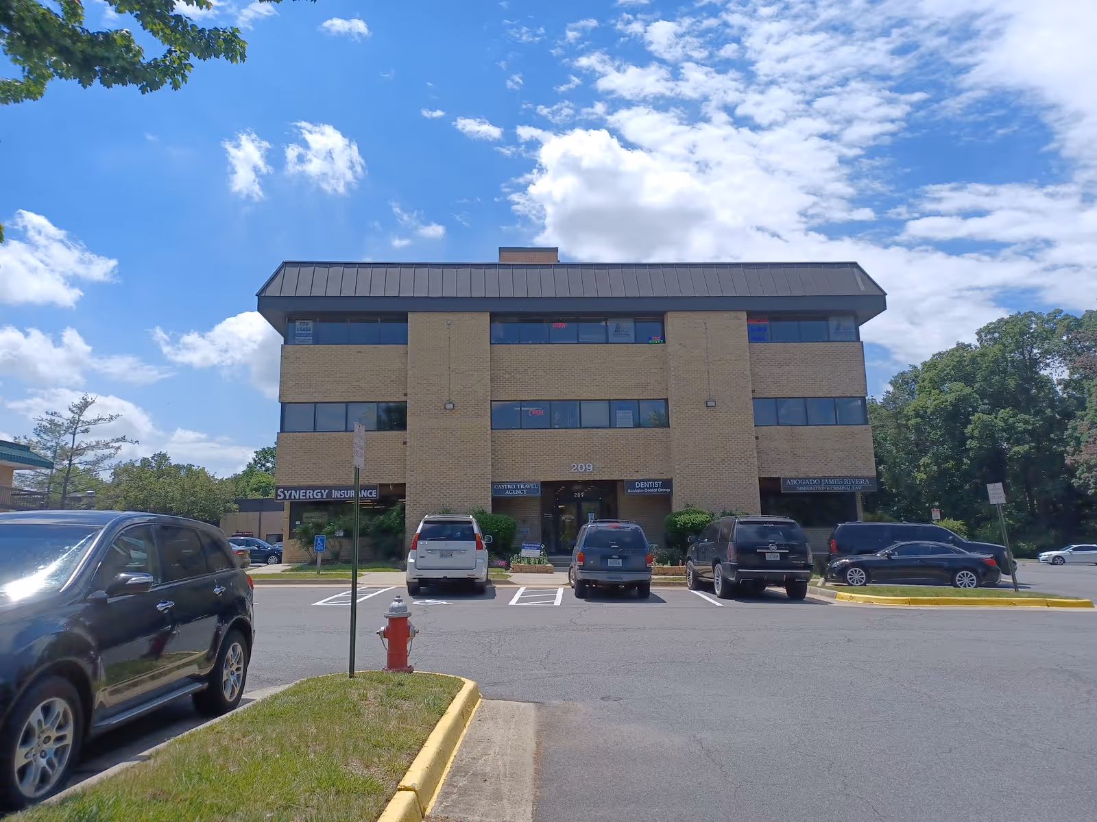 SYNERGY HomeCare building, a three-story brick structure, with cars parked in front.