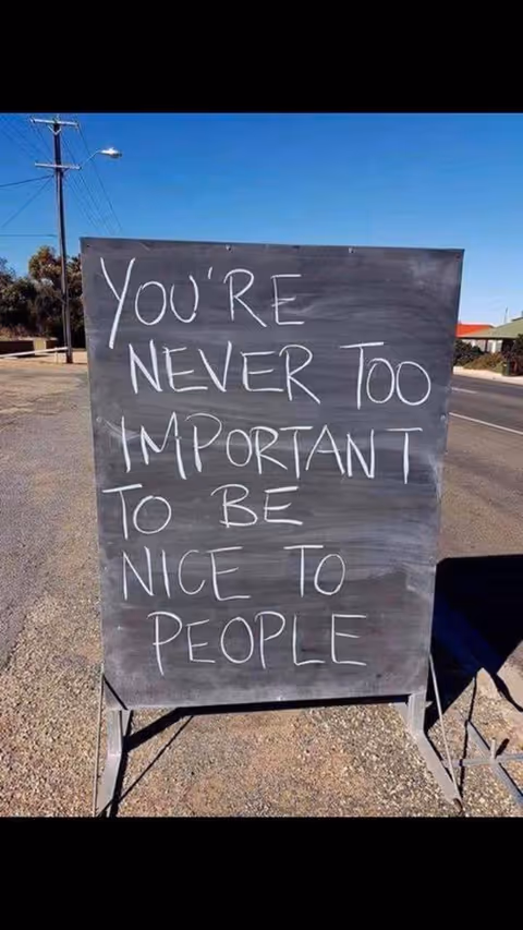 A chalkboard sign on a street reads You're never too important to be nice to people.