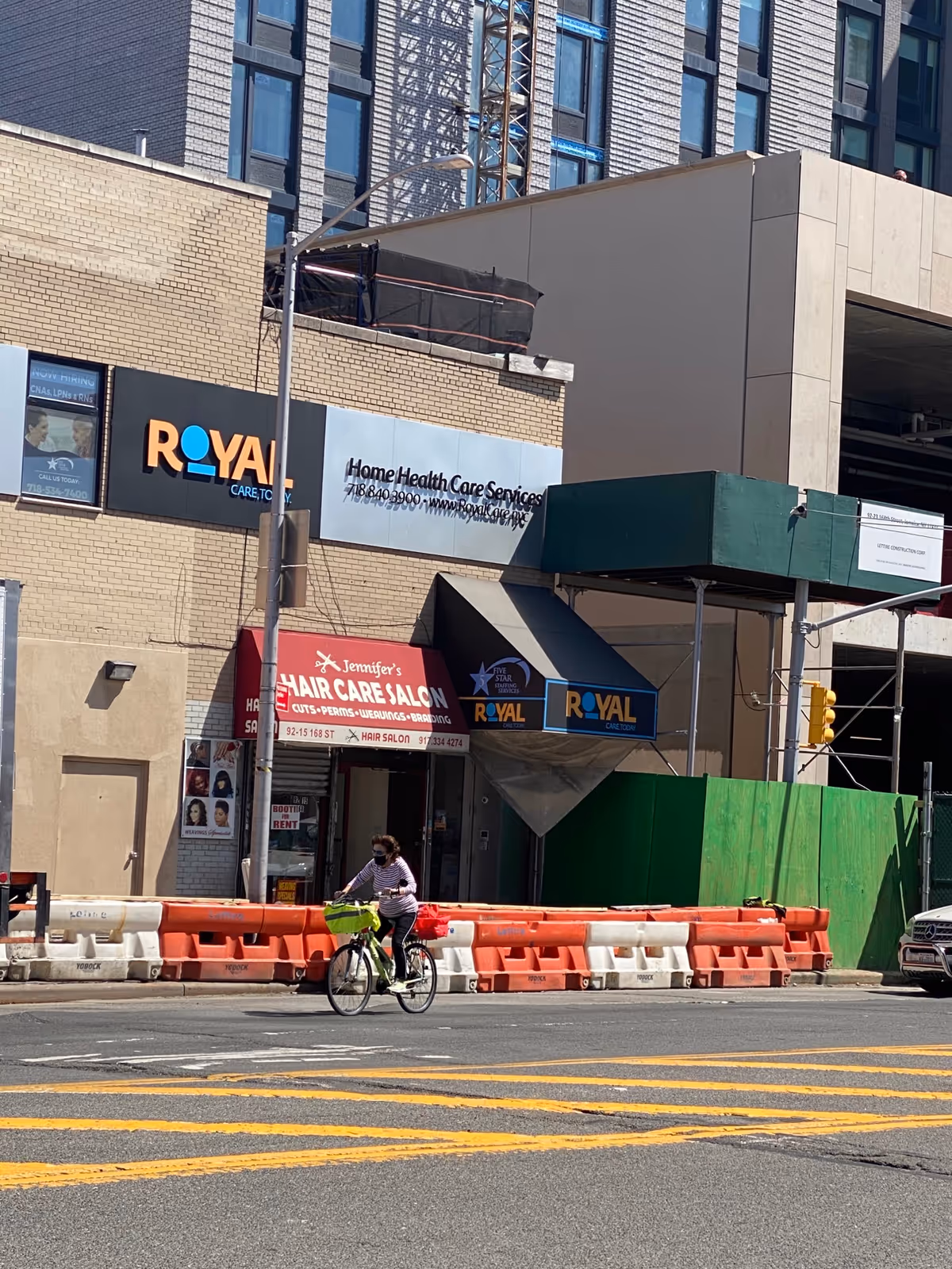 City street exterior with Royal Care signage and a cyclist passing by.
