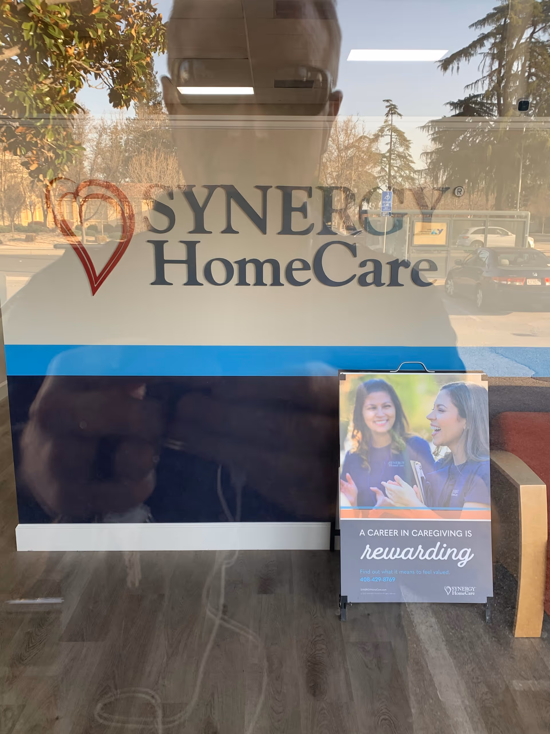 Glass wall with SYNERGY HomeCare logo and a career poster near the entrance
