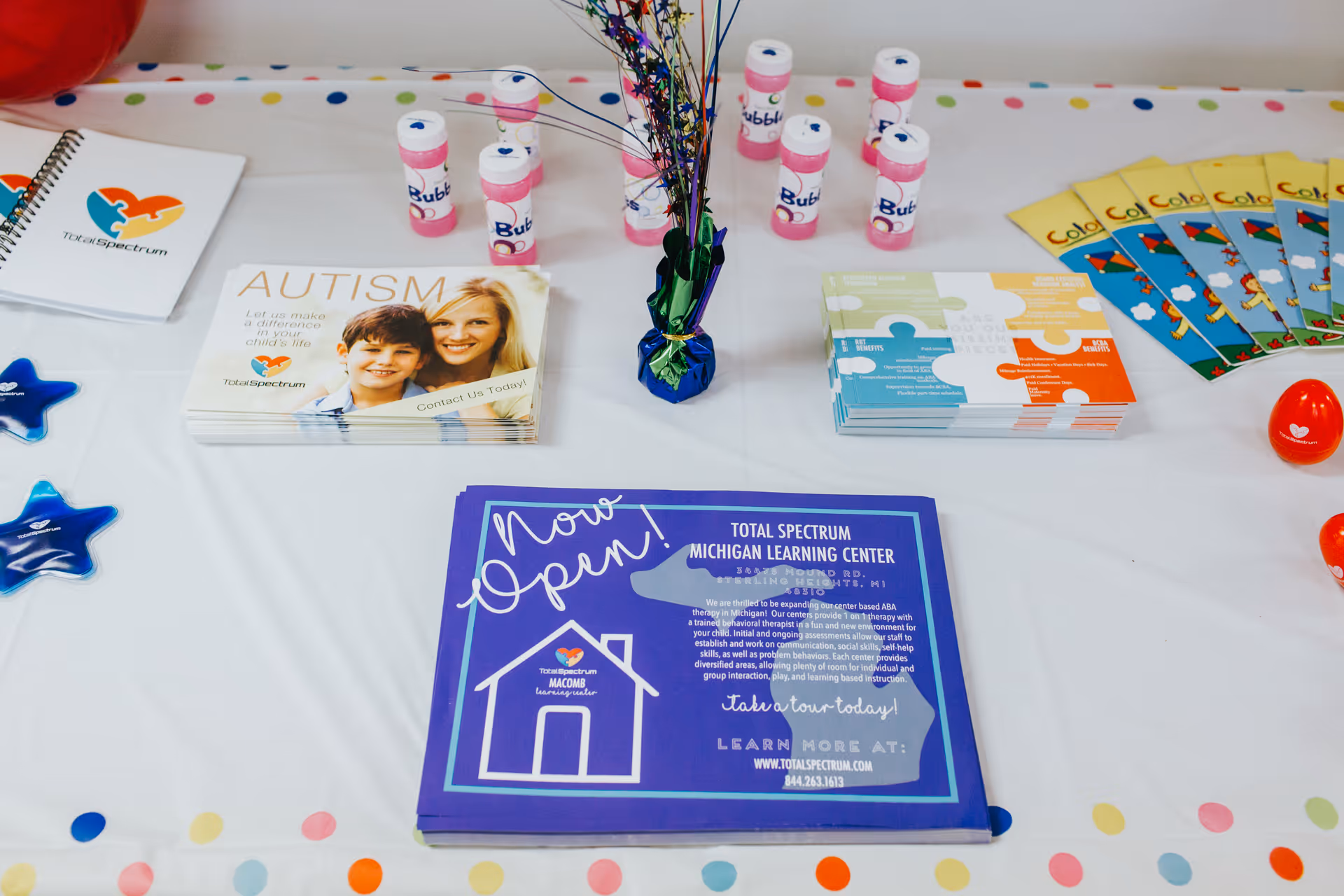 Table with autism awareness brochures and promotional materials from Total Spectrum ABA.