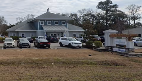 Front view of a Senior Helpers facility with a parking lot and sign.