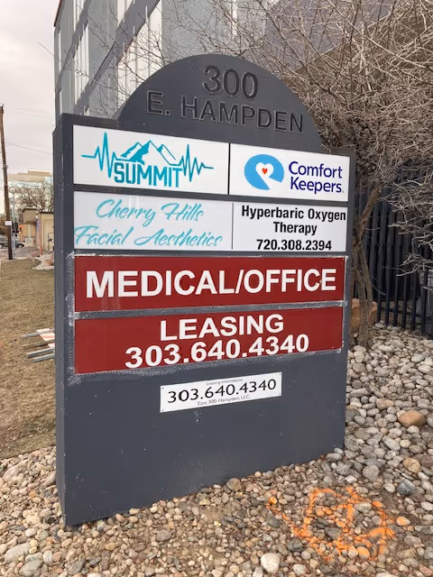 Outdoor building-front sign for Comfort Keepers Home Care among other businesses.